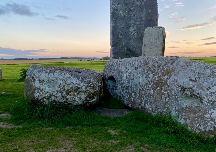 a close-up shot of several of the stones at stonehenge at sunset