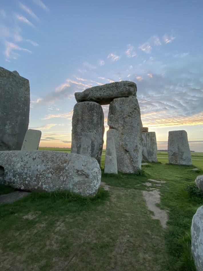 A close-up photo of Stonehenge, with a stone trilithon at the center and a fallen trilithon nearby