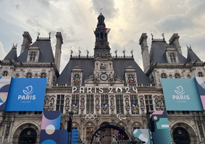 A photo of Paris City Hall, decked out for the 2024 Olympics with flags and banners