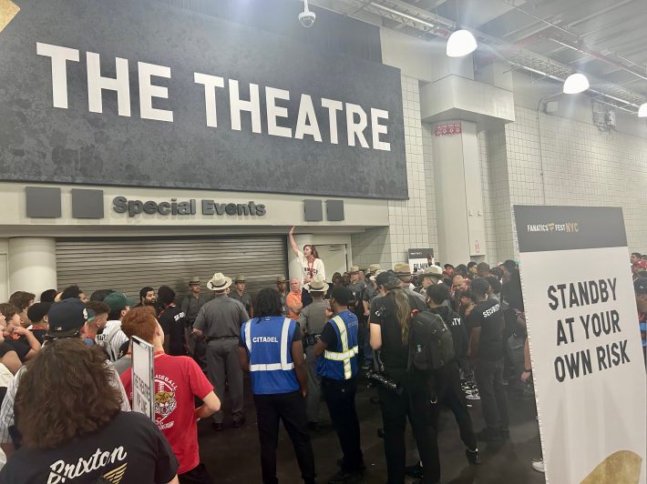 A large crowd waits to get into the theater.