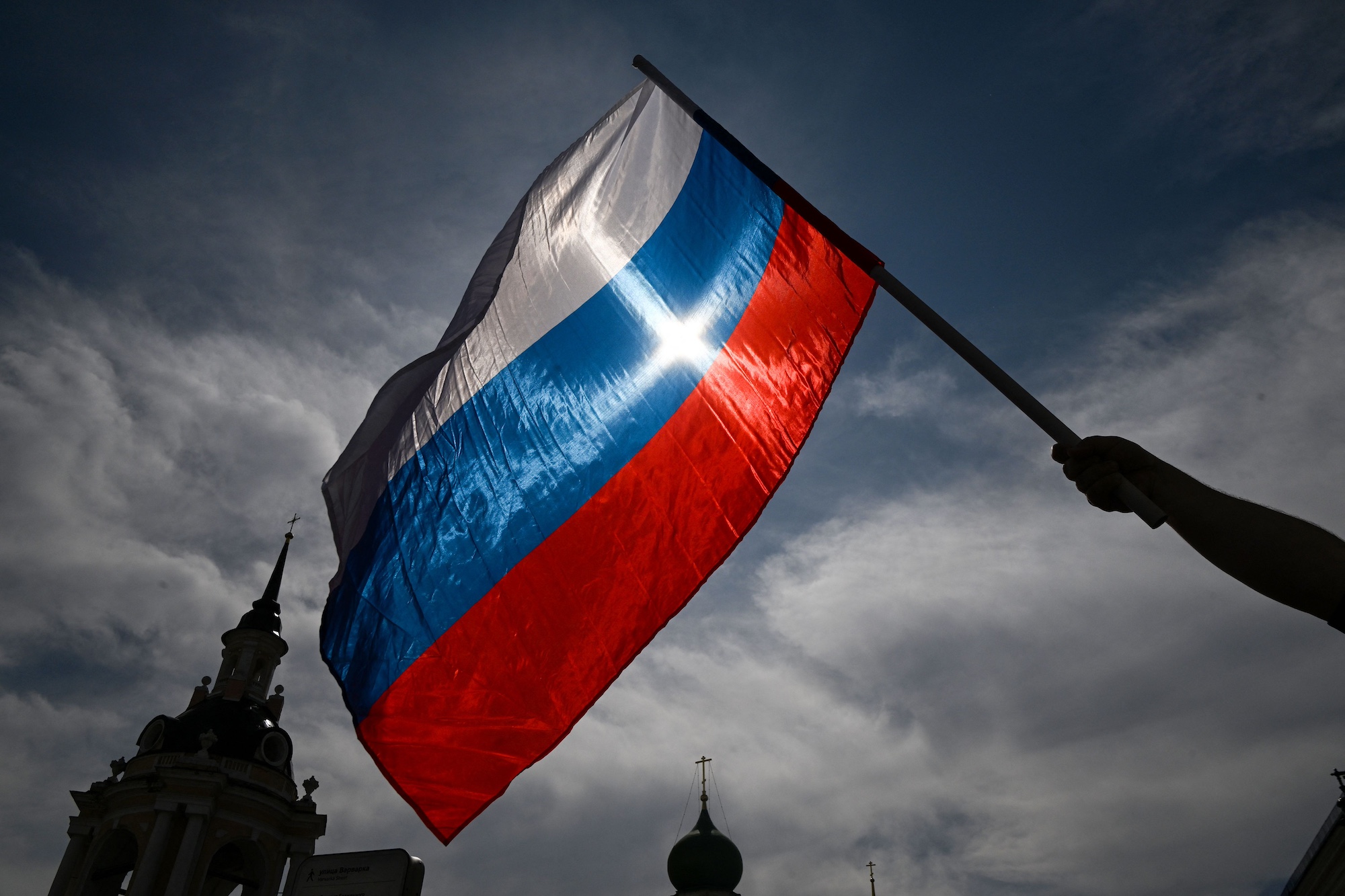 A man waves the Russian national flag as he arrives at the patriotic concert at the Red square in downtown Moscow ahead the Russia Day on June 11, 2023. (Photo by Kirill KUDRYAVTSEV / AFP) (Photo by KIRILL KUDRYAVTSEV/AFP via Getty Images)