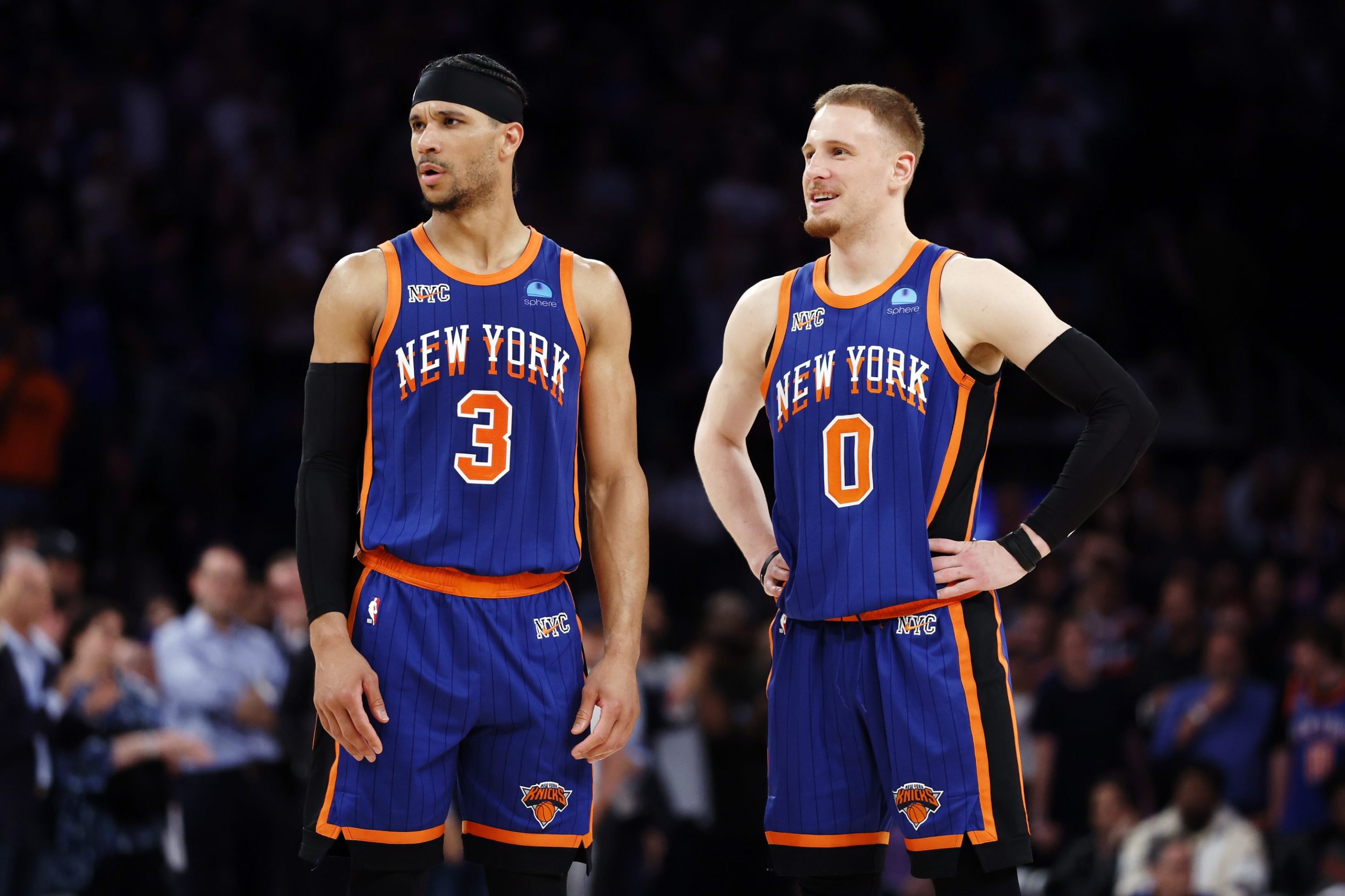 Donte DiVincenzo talks with Josh Hart of the New York Knicks. Both are standing on the court, looking at something to the left off camera.