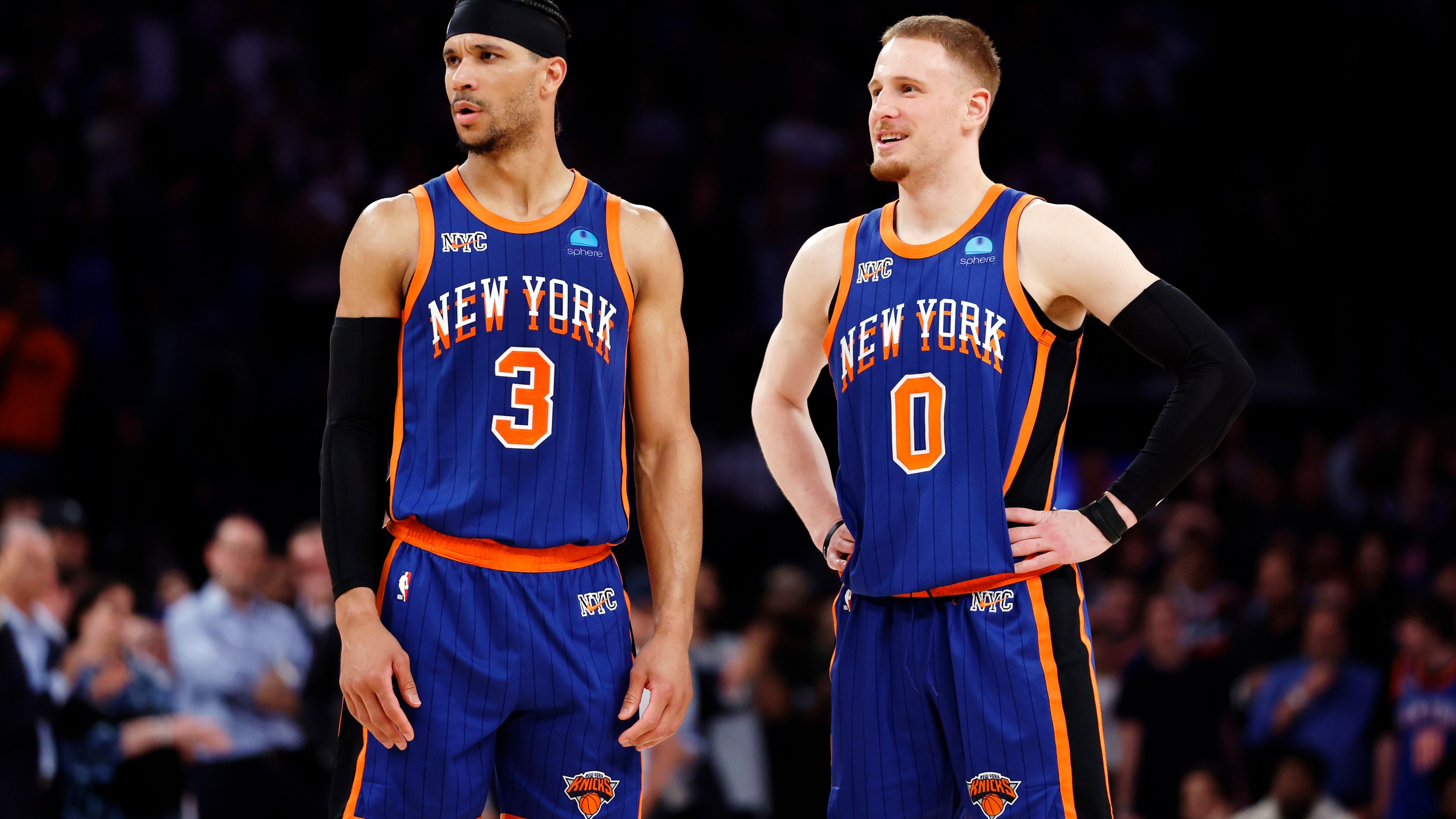 Donte DiVincenzo talks with Josh Hart of the New York Knicks. Both are standing on the court, looking at something to the left off camera.