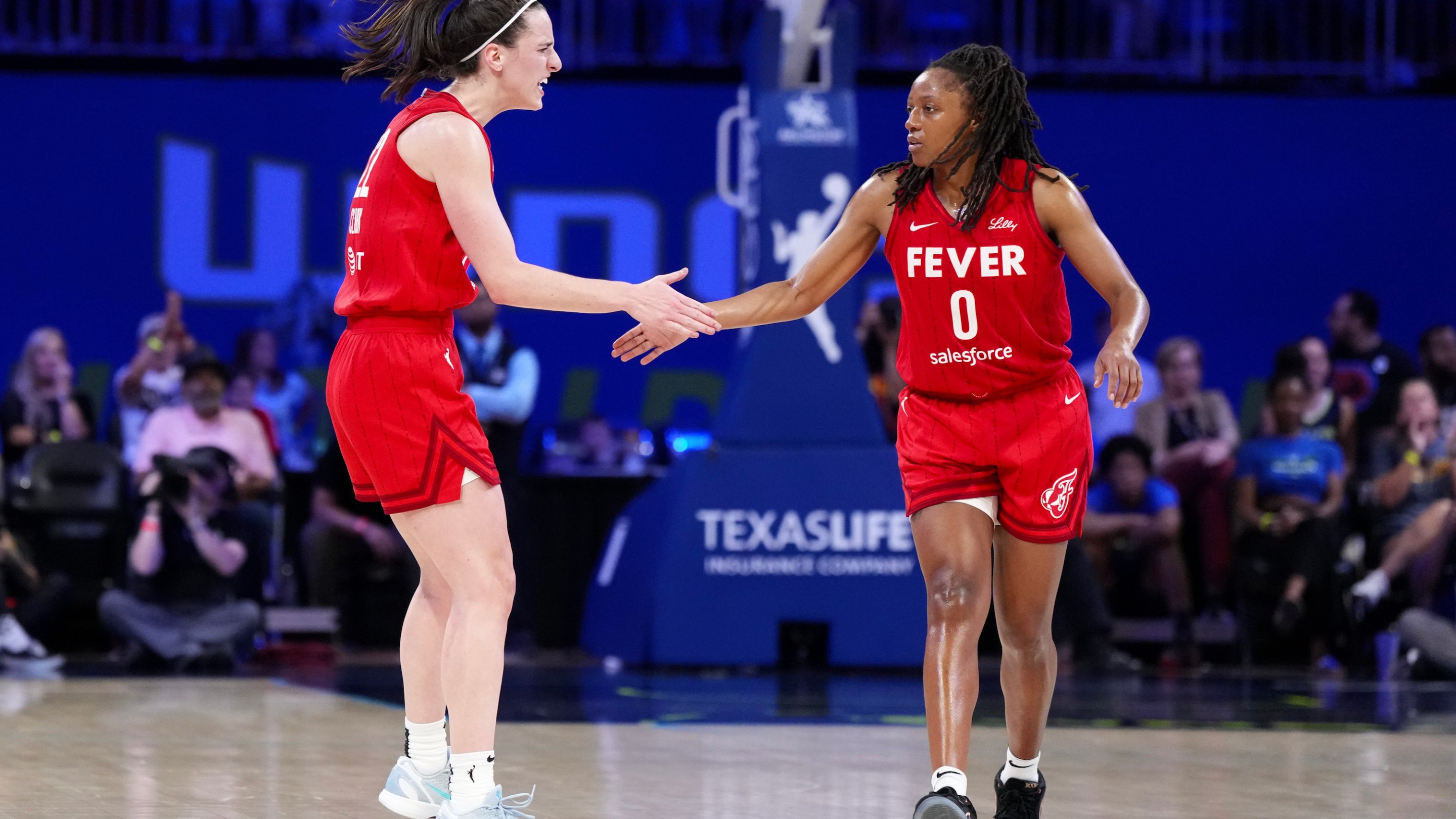 Kelsey Mitchell #0 of the Indiana Fever is congratulated by Caitlin Clark #22 after scoring during the second half against the Dallas Wings at College Park Center on September 01, 2024 in Arlington, Texas.