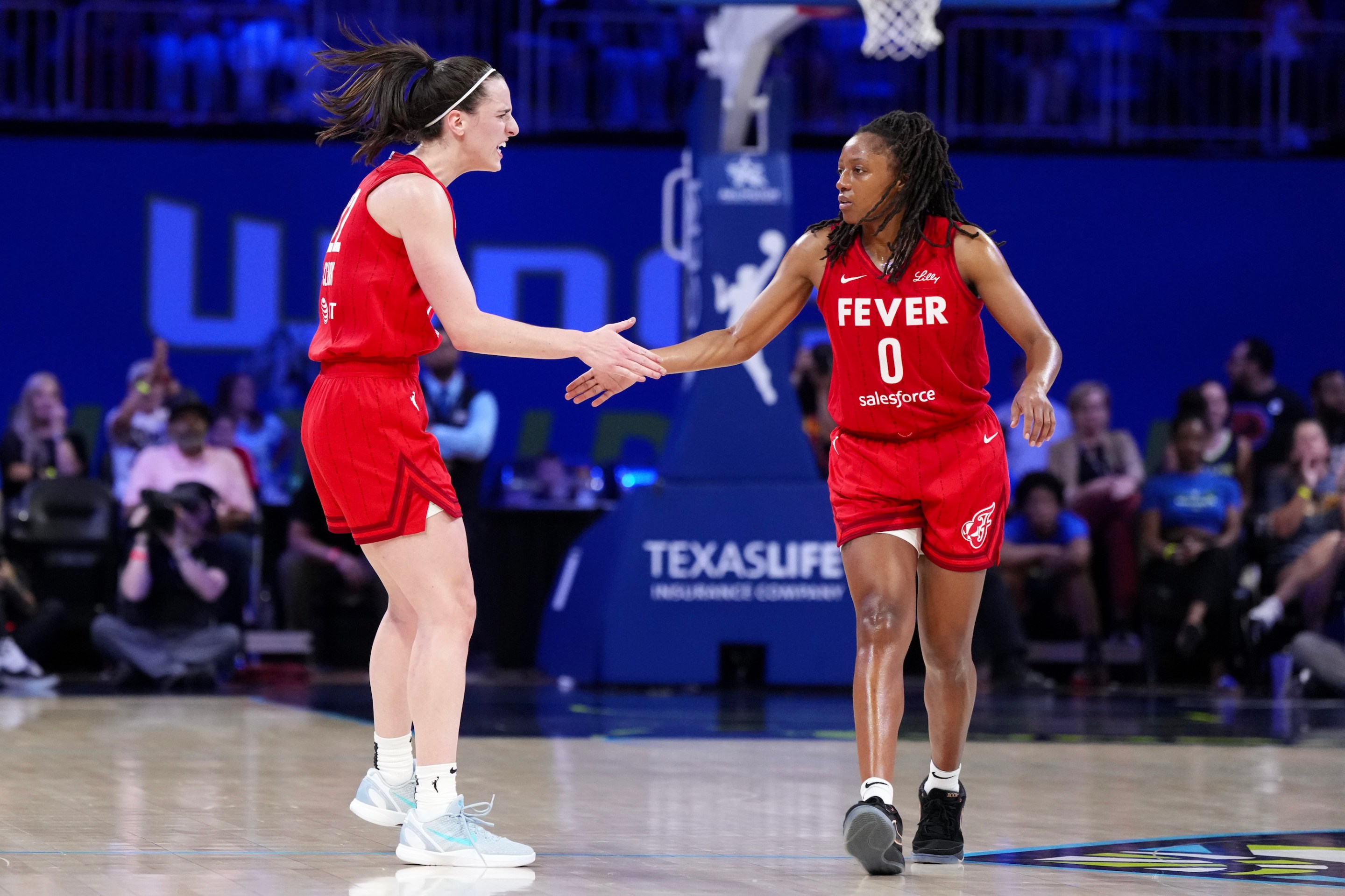 Kelsey Mitchell #0 of the Indiana Fever is congratulated by Caitlin Clark #22 after scoring during the second half against the Dallas Wings at College Park Center on September 01, 2024 in Arlington, Texas.