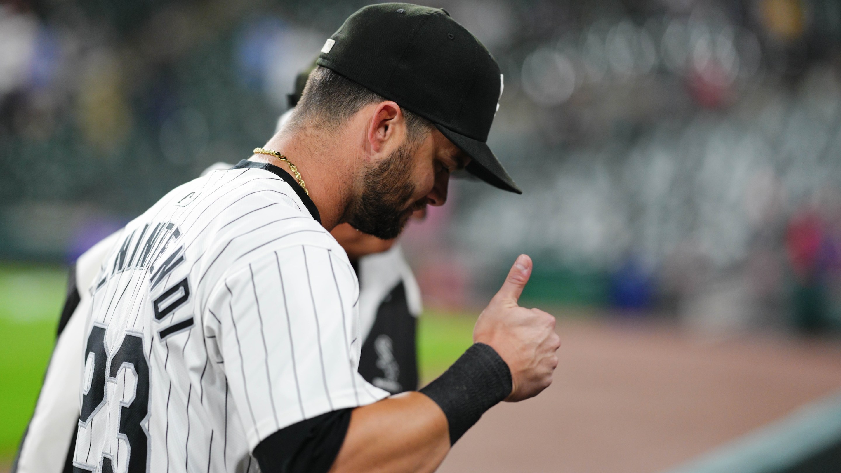 Andrew Benintendi gives a kind of grim looking thumbs-up in profile after completing a TV interview following his walk-off hit in the Chicago White Sox's win on September 24.