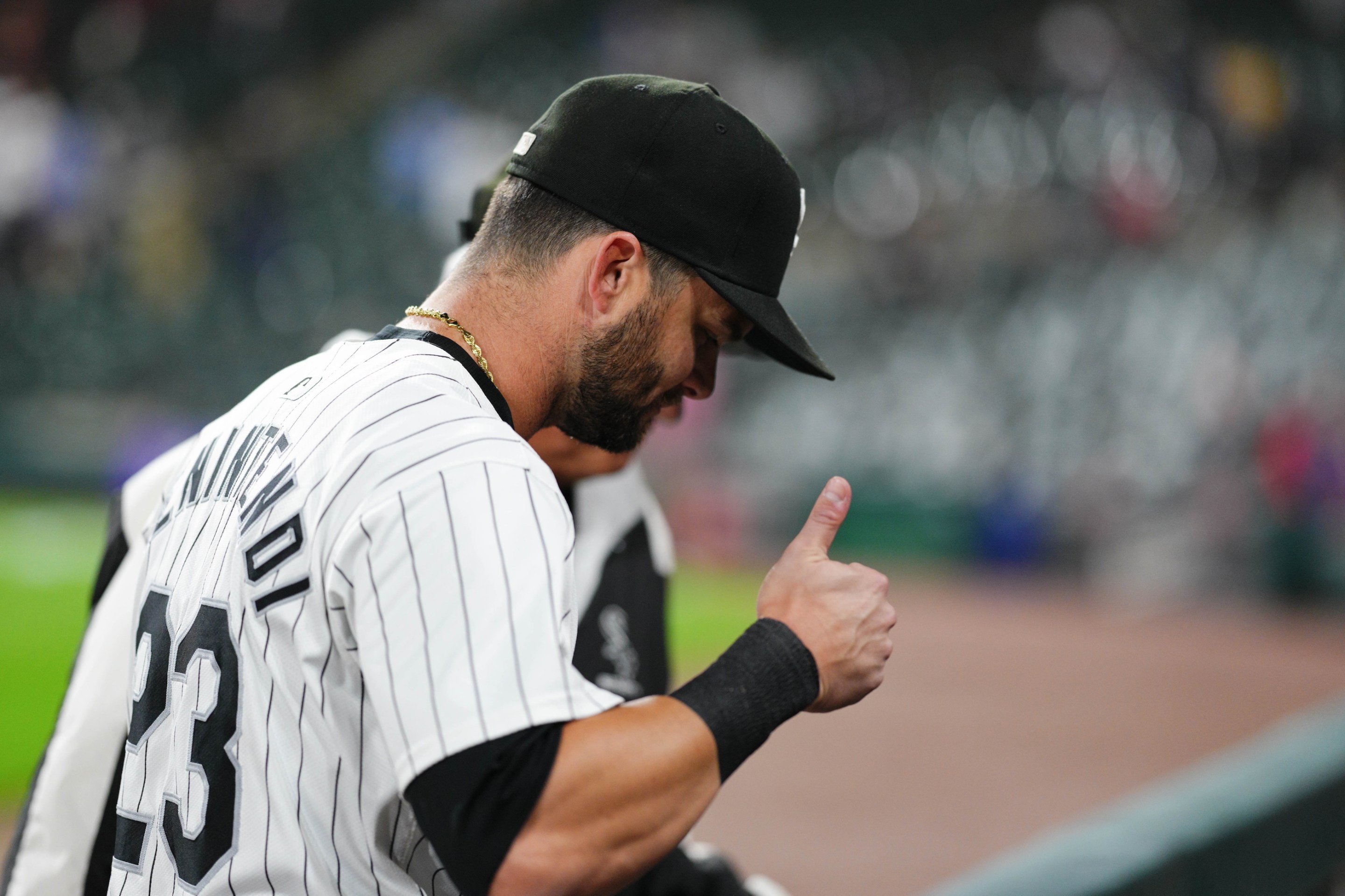 Andrew Benintendi gives a kind of grim looking thumbs-up in profile after completing a TV interview following his walk-off hit in the Chicago White Sox's win on September 24.