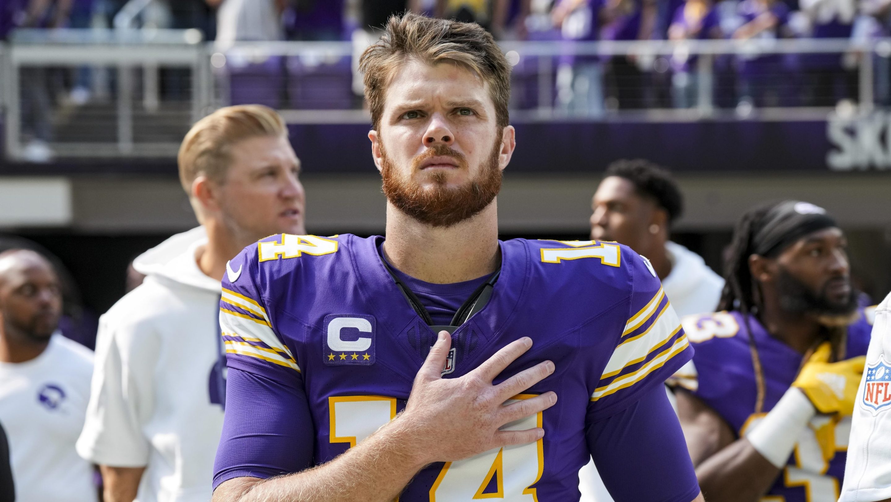 Quarterback Sam Darnold #14 of the Minnesota Vikings stands on the sidelines during the national anthem prior to an NFL football game against the Houston Texans, at U.S. Bank Stadium on September 22, 2024 in Minneapolis, Minnesota.