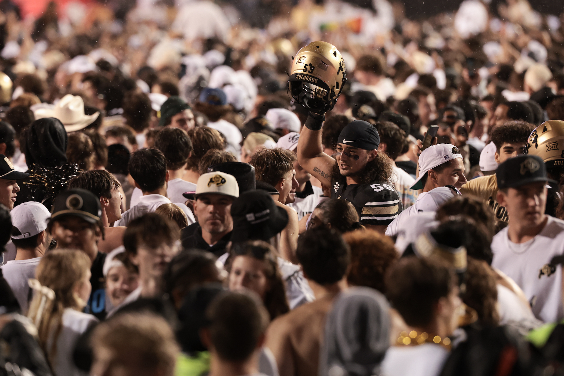 University of Colorado students swarm the field and surround football player Yahya Attia after the Buffaloes overtime win against the Baylor Bears, 38-31.