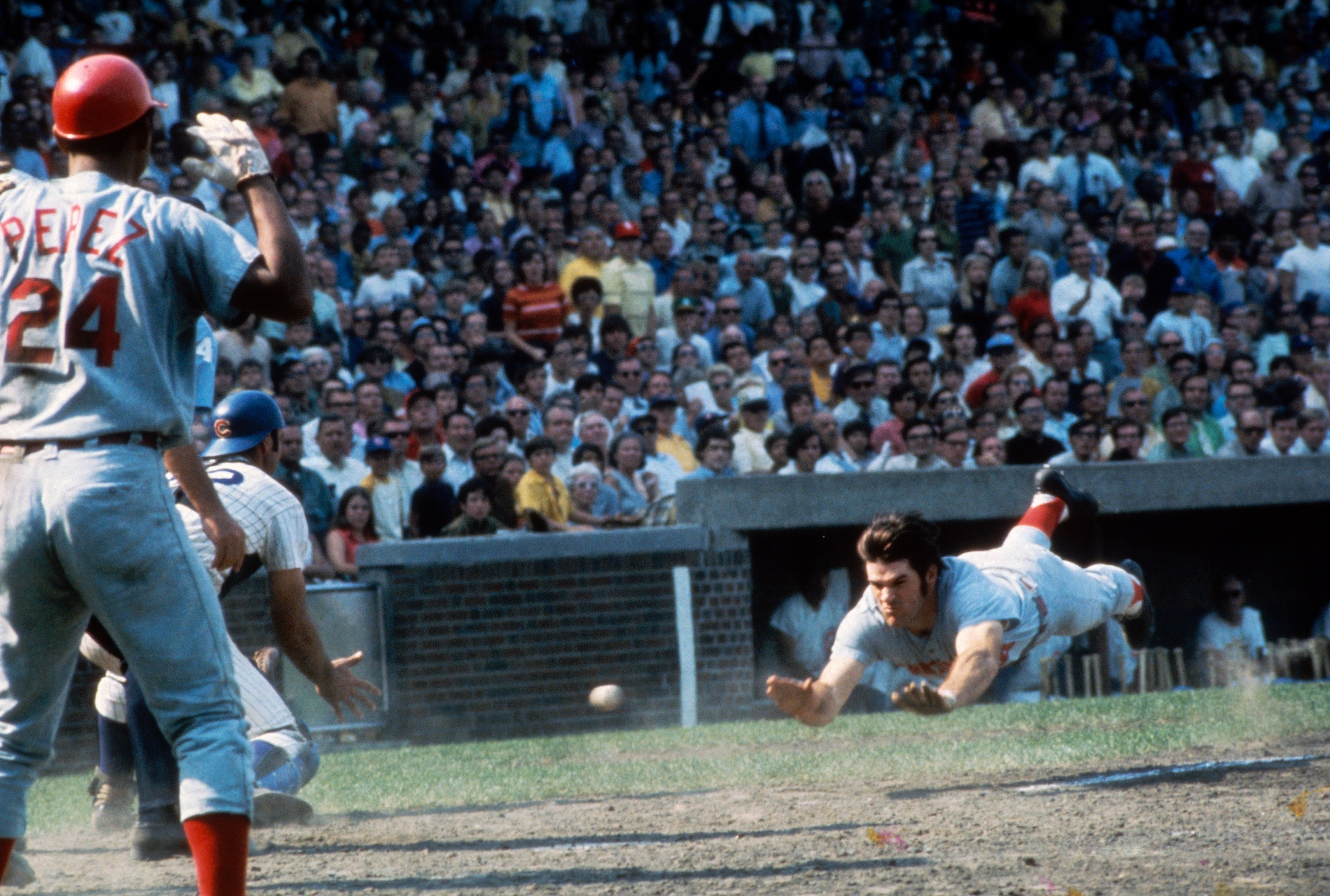 Pete Rose of the Cincinnati Reds dives head first into home plate during a game against the Chicago Cubs at Wrigley Field during the early 1970s in Chicago