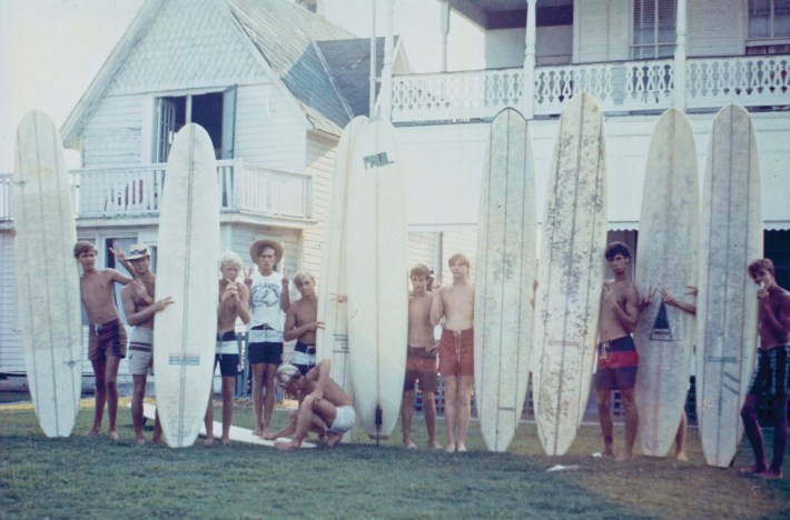 Surfers pose with their boards