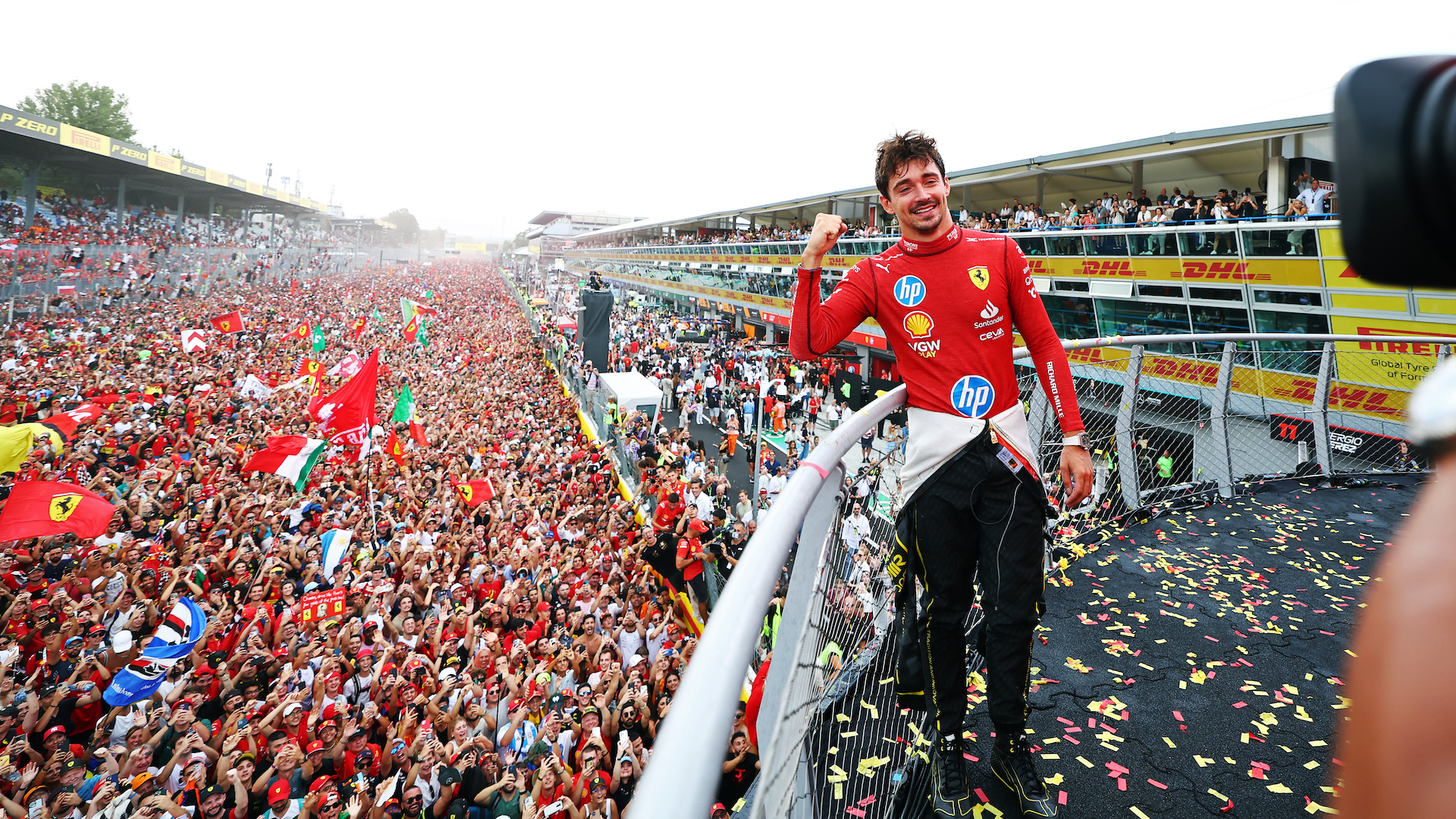 Race winner Charles Leclerc of Monaco and Ferrari poses for a picture on the podium, with the fans down on the track during the F1 Grand Prix of Italy.