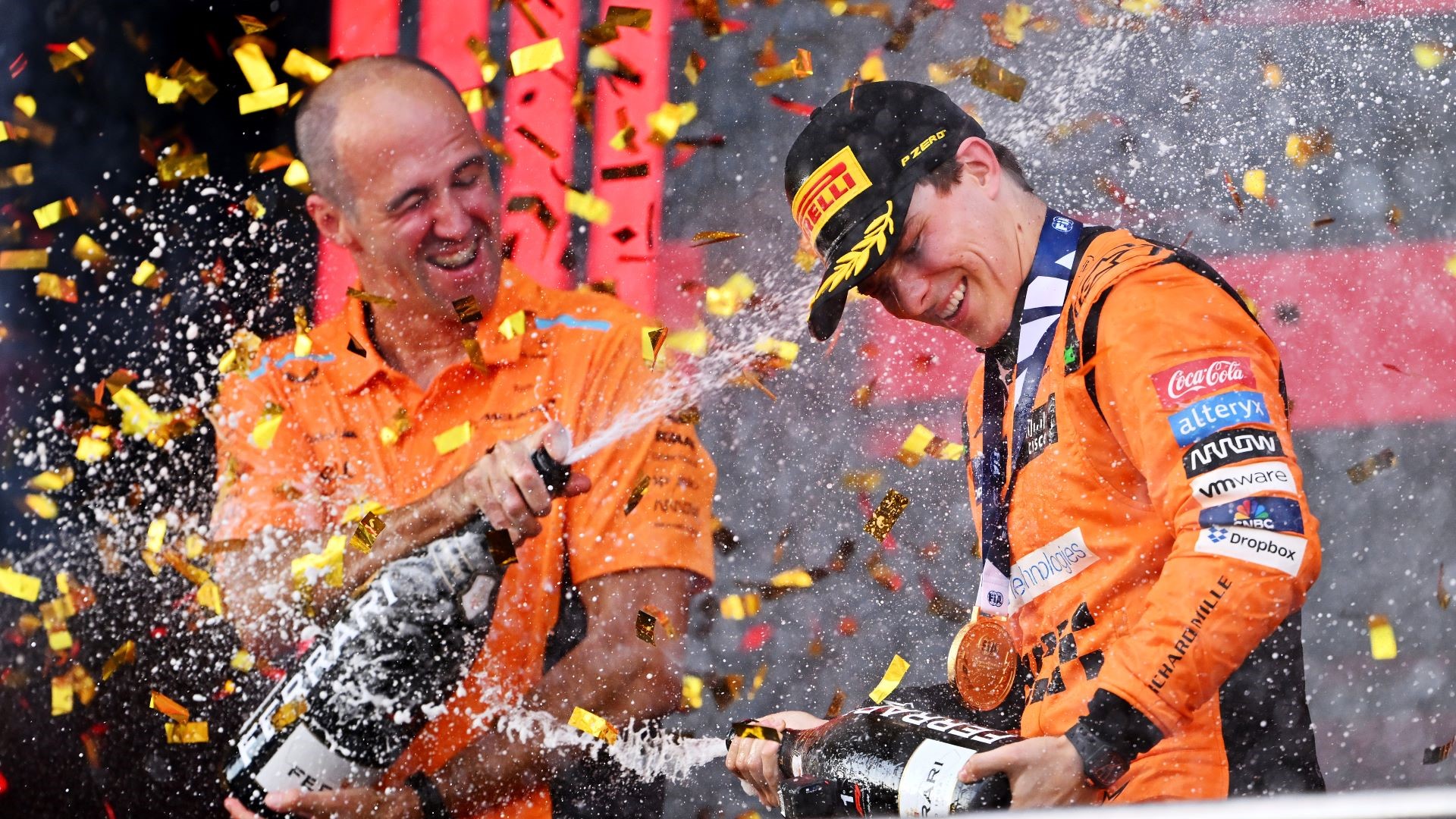 Race winner Oscar Piastri of Australia and McLaren and McLaren race engineer Tom Stallard celebrate on the podium.