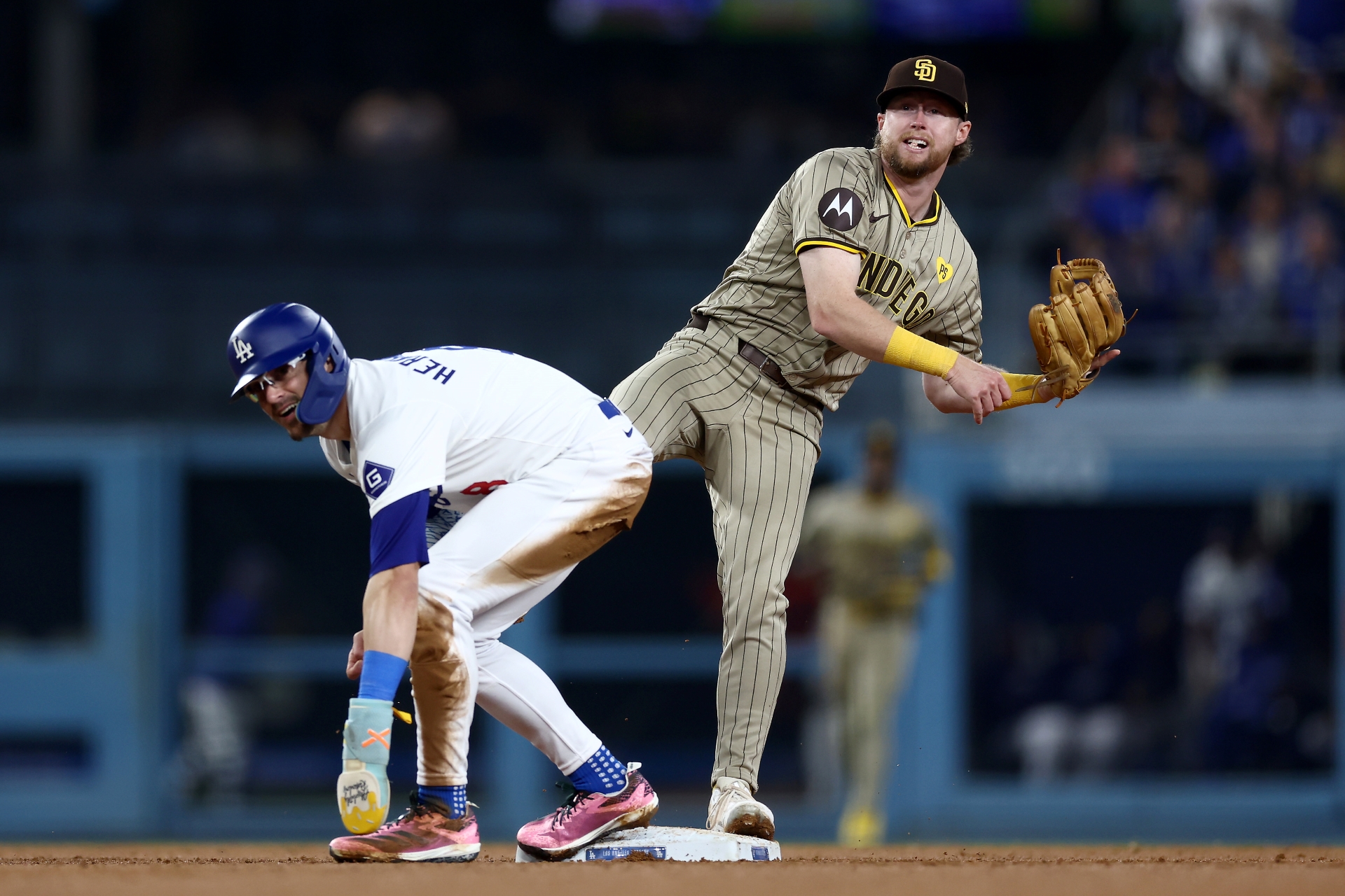 Jake Cronenworth #9 of the San Diego Padres watches after throwing the ball to first base as part of a triple play as Enrique Hernández #8 of the Los Angeles Dodgers ducks.