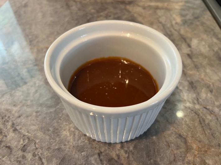 A small ramekin of dark caramel.