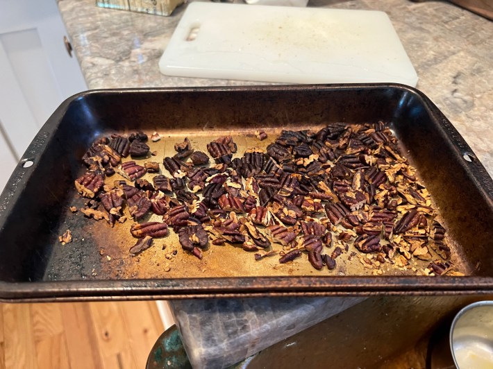 Pecans are burned to shit in a small baking pan.