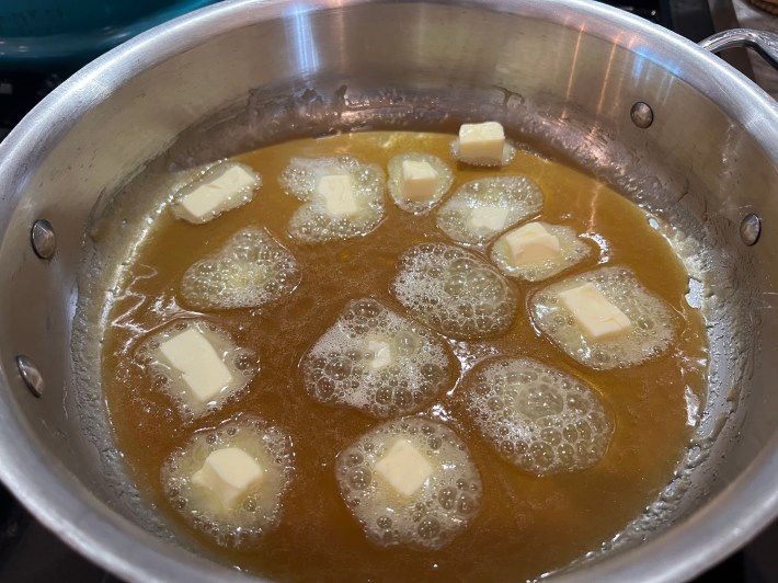 Cubes of butter melting in a pool of caramelized sugar.