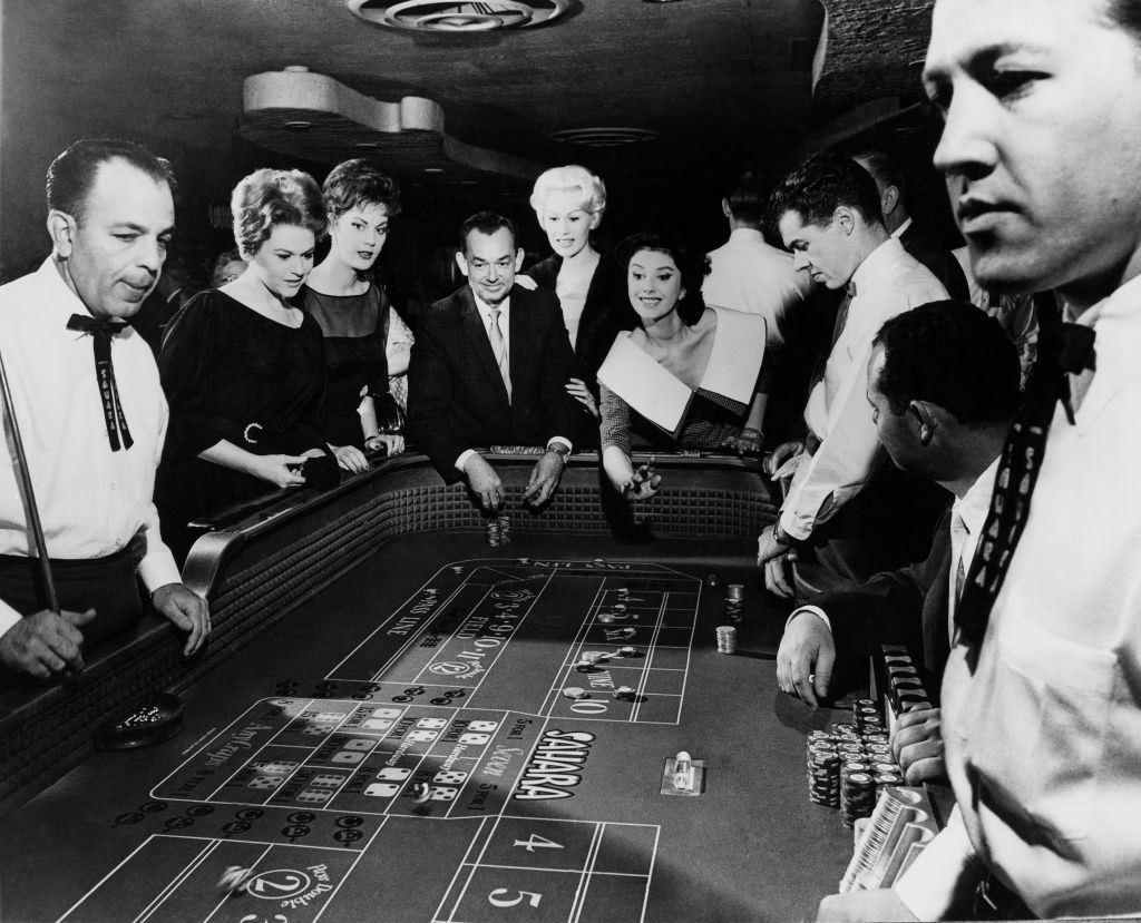 A black and white photo of people around a craps table gambling in Las Vegas in 1963