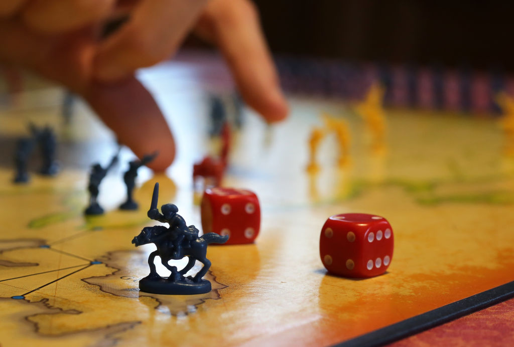 A family plays the board game Risk at home