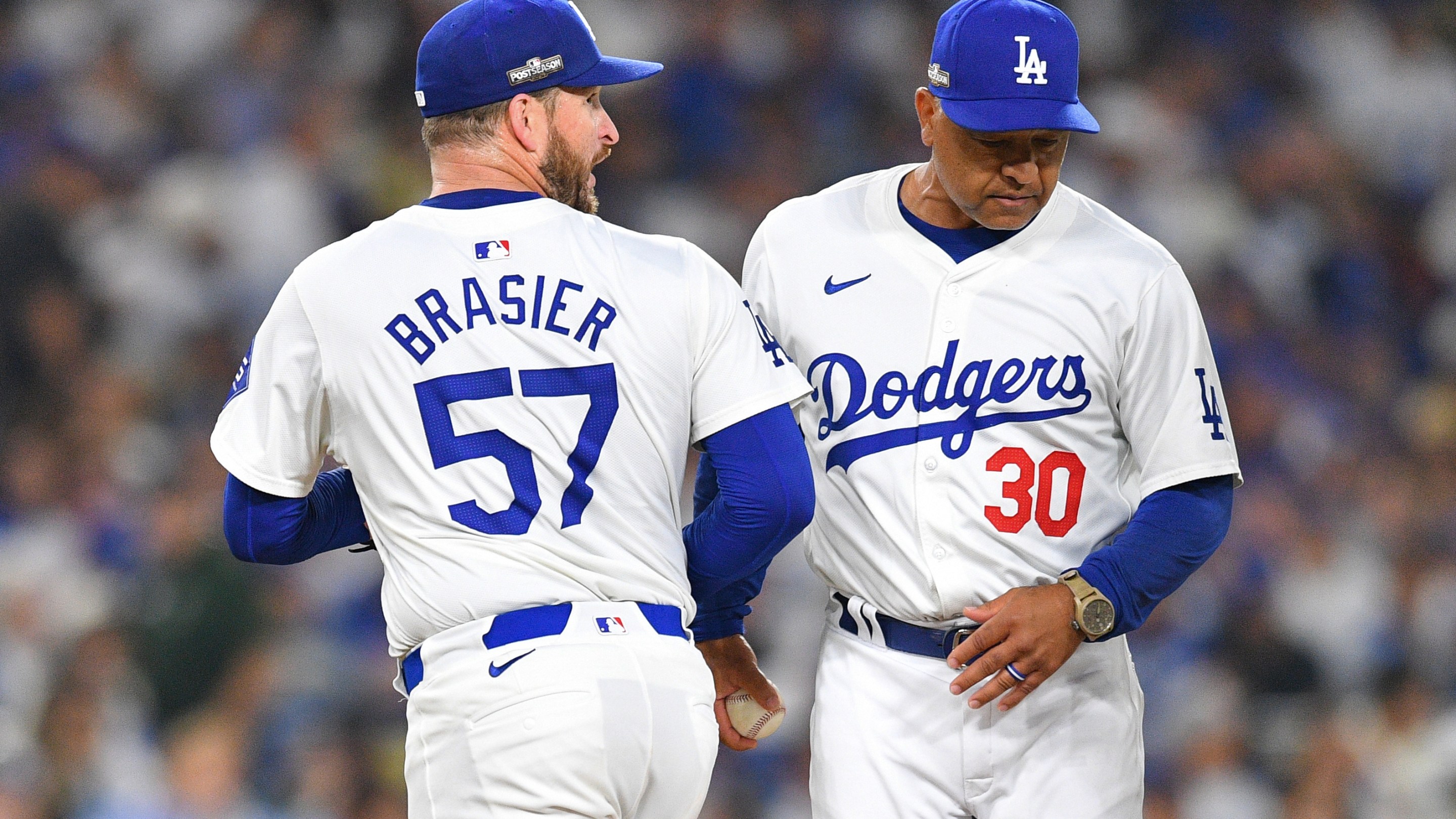 Los Angeles Dodgers pitcher Ryan Brasier (57) hands the ball to manager Dave Roberts as he is taken out of the game one of the National League Division Series game between the San Diego Padres and the Los Angeles Dodgers on October 5, 2024.