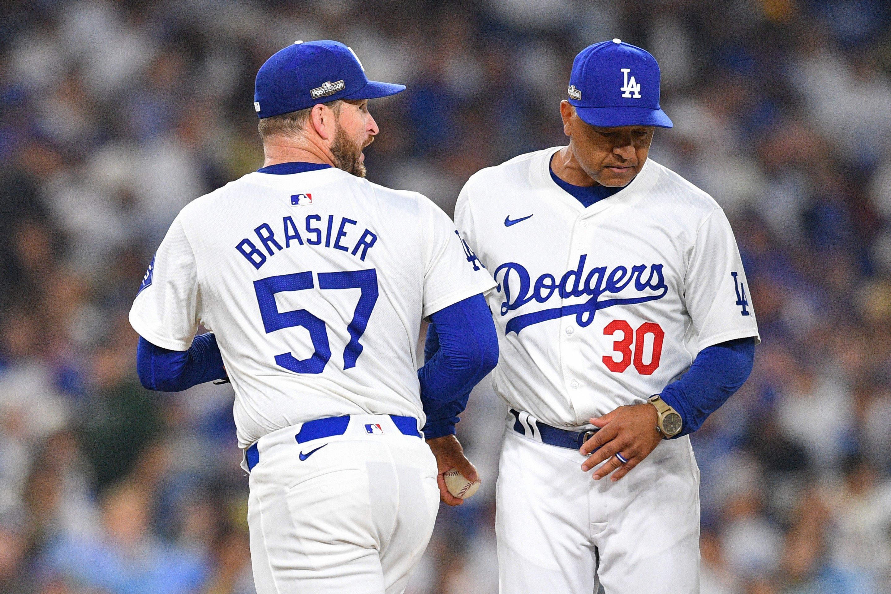 Los Angeles Dodgers pitcher Ryan Brasier (57) hands the ball to manager Dave Roberts as he is taken out of the game one of the National League Division Series game between the San Diego Padres and the Los Angeles Dodgers on October 5, 2024.