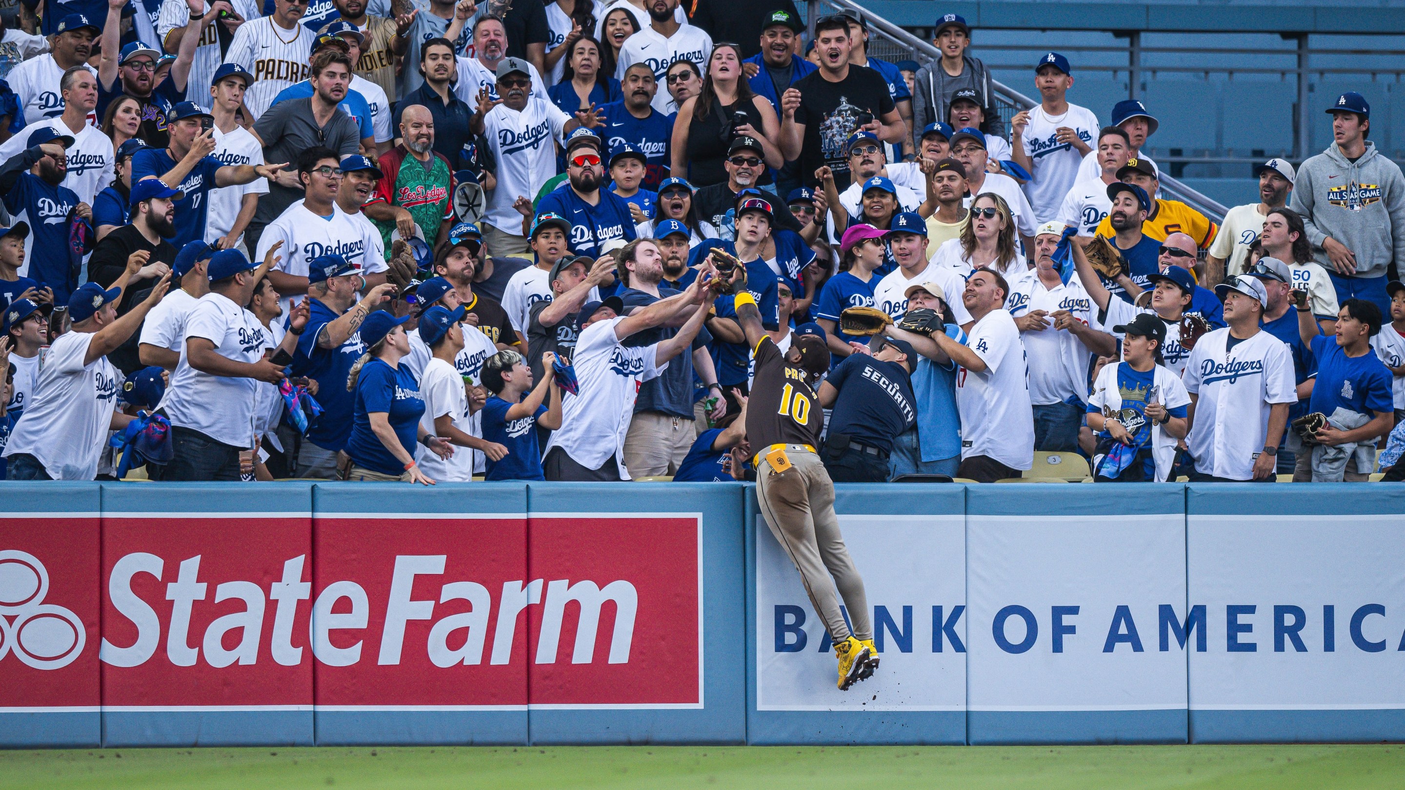 Jurickson Profar #10 of the San Diego Padres makes a jumping catch into the crowd to rob a home run during game two of the National League Divisional Series against the Los Angeles Dodgers at Dodger Stadium on October 6, 2024, in Los Angeles, California. (Photo by Matt Thomas/San Diego Padres/Getty Images)