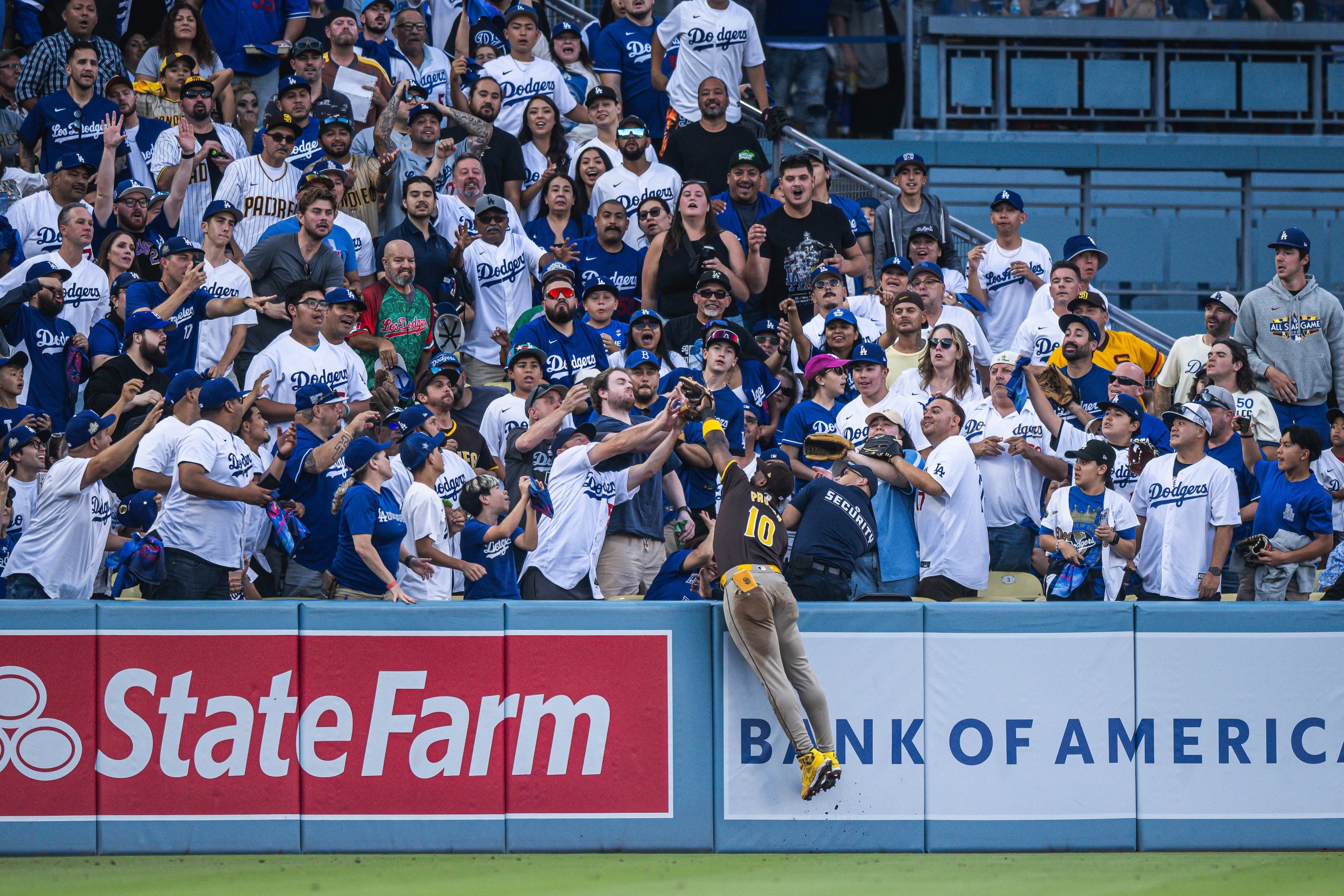 Jurickson Profar #10 of the San Diego Padres makes a jumping catch into the crowd to rob a home run during game two of the National League Divisional Series against the Los Angeles Dodgers at Dodger Stadium on October 6, 2024, in Los Angeles, California. (Photo by Matt Thomas/San Diego Padres/Getty Images)