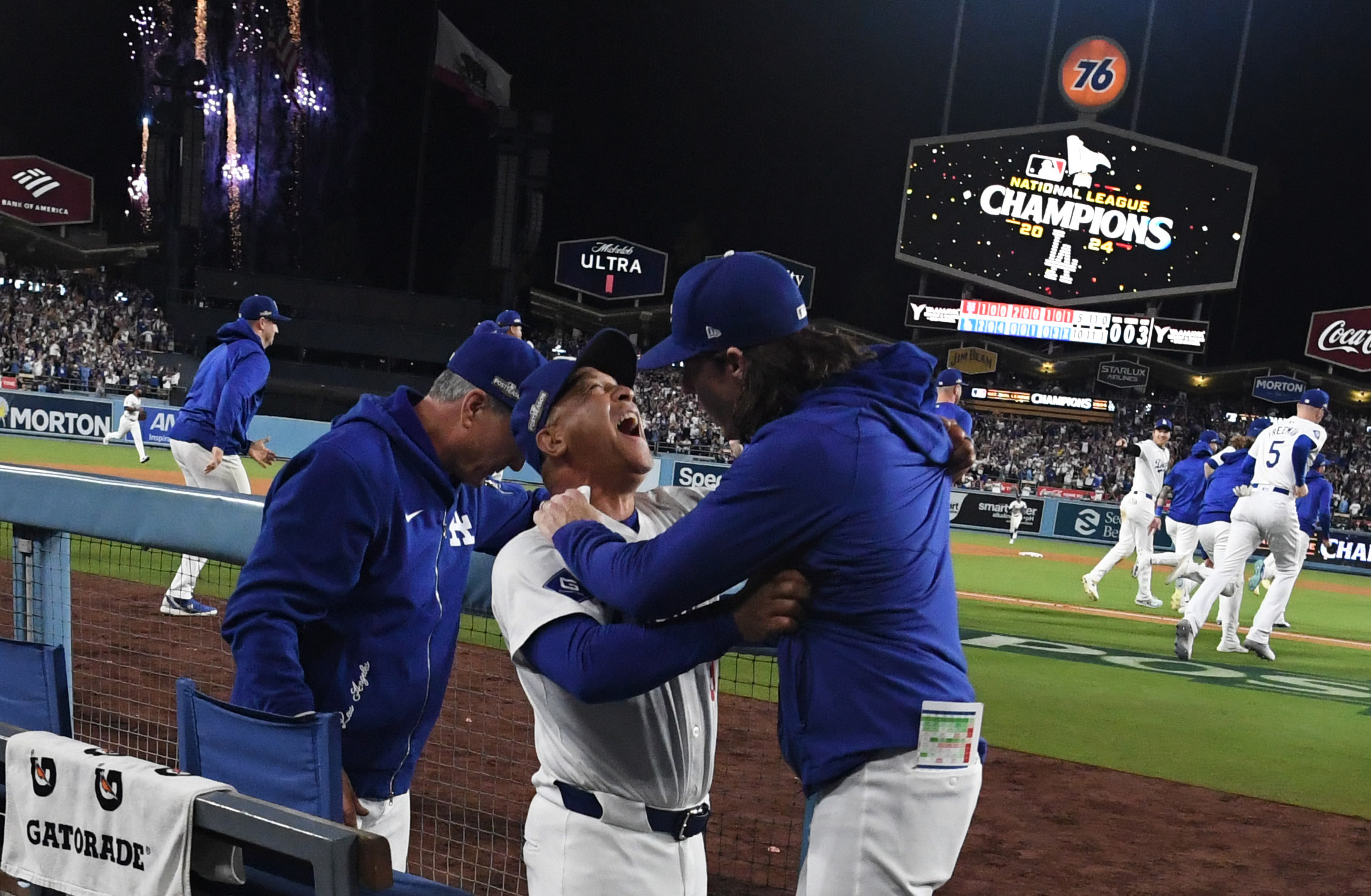 Manager Dave Roberts celebrates with bench coach Danny Lehmann, right, as the Los Angeles Dodgers celebrate after defeating the New York Mets 10-5 to win game 6 of a National League Championship Series at Dodger Stadium in Los Angeles on Sunday, October 20, 2024.