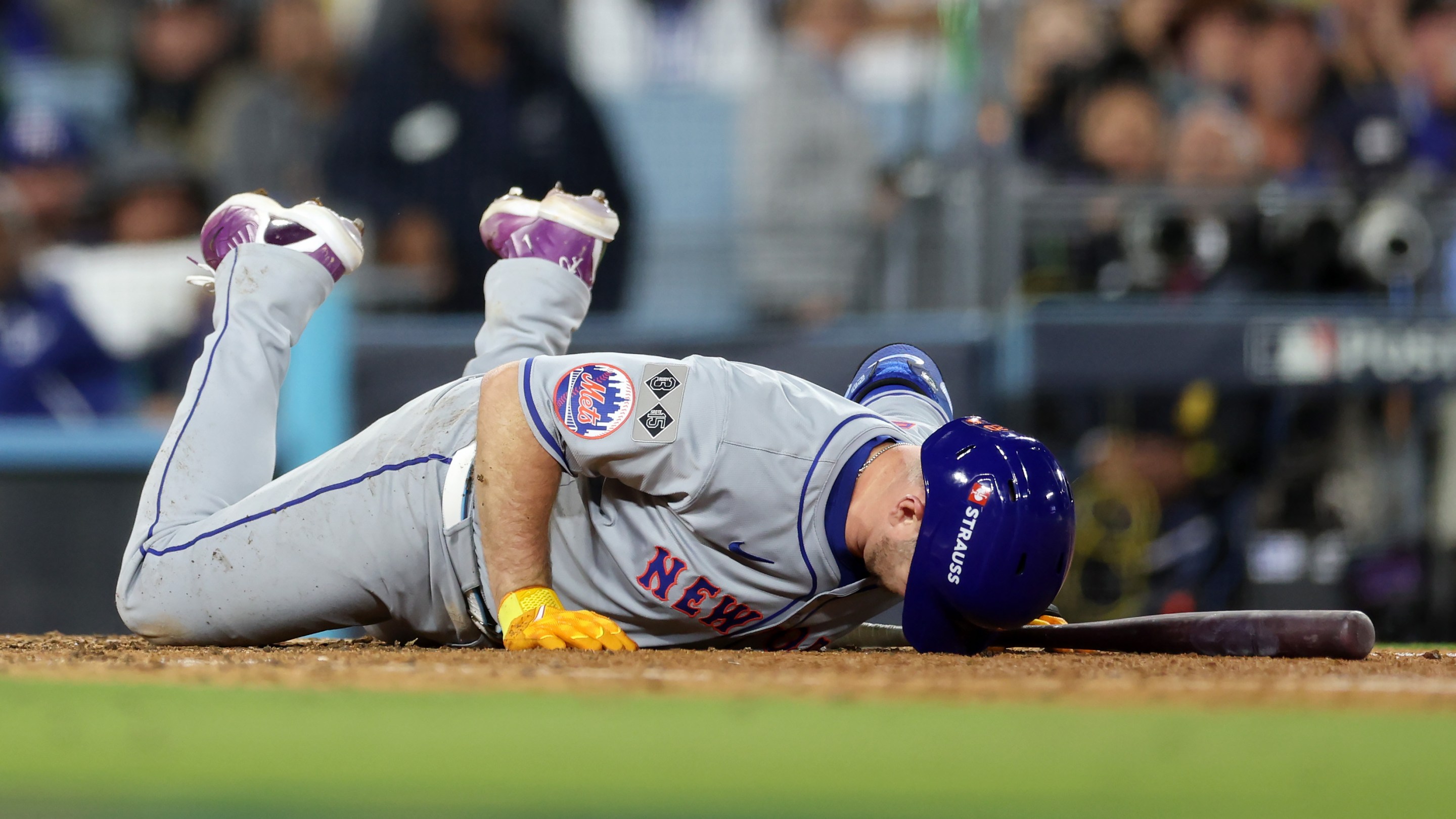 Pete Alonso flat on the ground with the brim of his helmet jammed into the earth after fouling a ball off his foot in Game Six of the NLCS in Los Angeles on October 20, 2024.