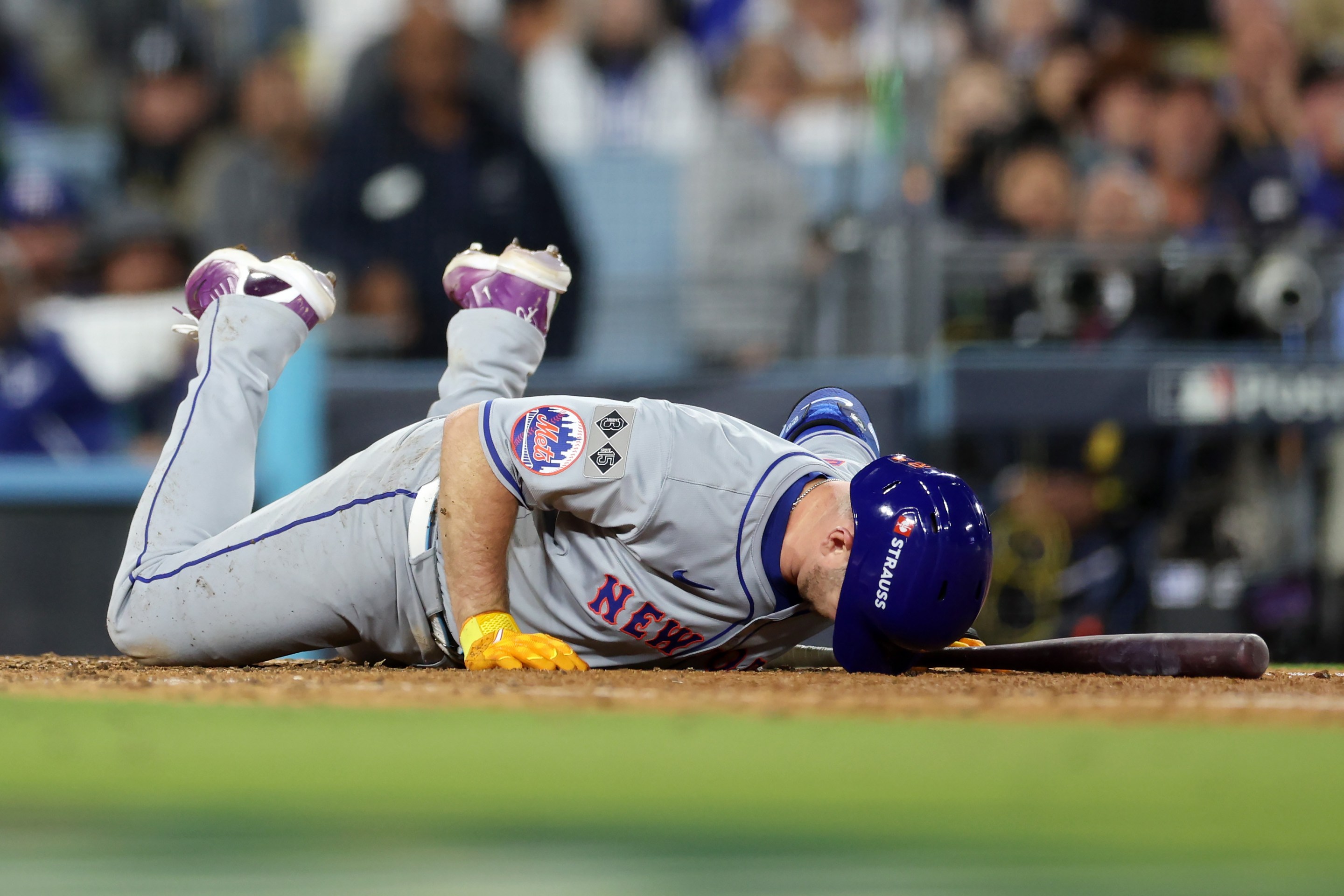 Pete Alonso flat on the ground with the brim of his helmet jammed into the earth after fouling a ball off his foot in Game Six of the NLCS in Los Angeles on October 20, 2024.