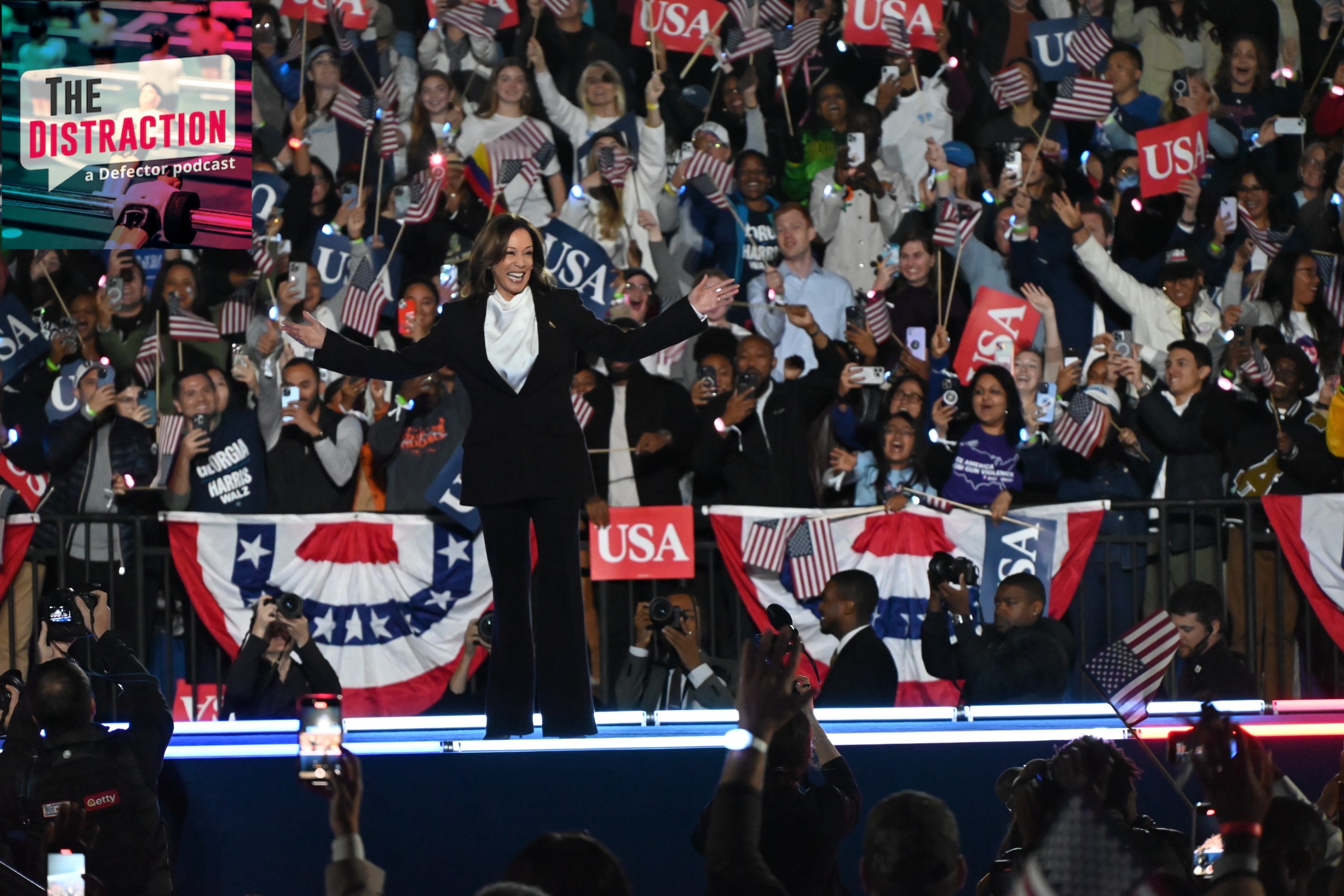 Kamala Harris smiling out at the crowd at her big rally in Washington, D.C. on October 29, 2024. There's a bunch of people cheering behind her and she's wearing a suit.