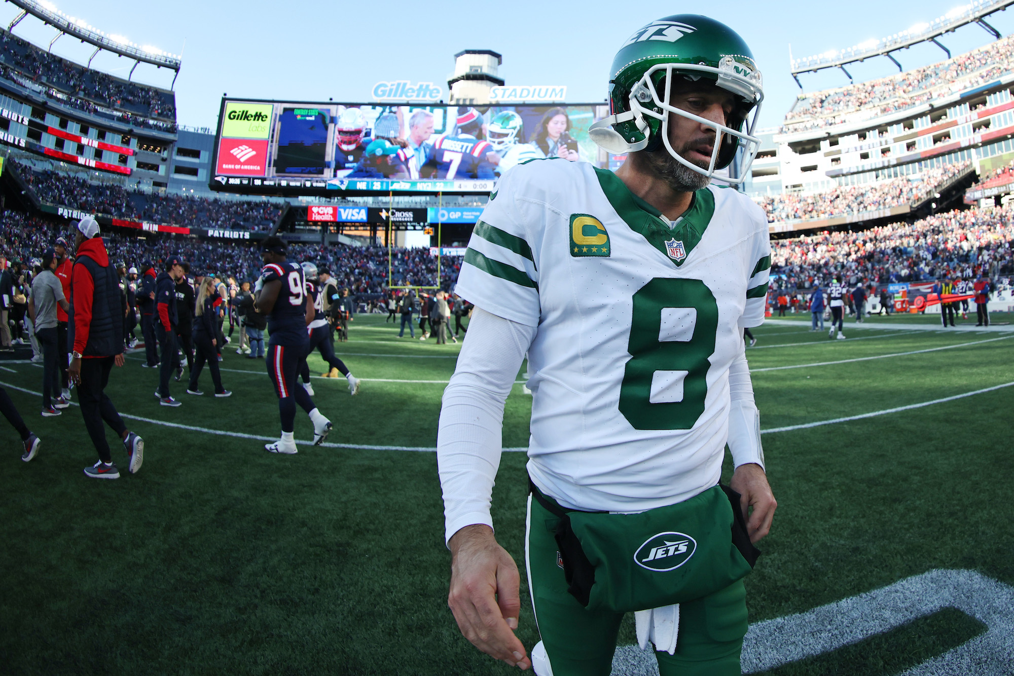 Aaron Rodgers #8 of the New York Jets walks off the field after the game against the New England Patriots