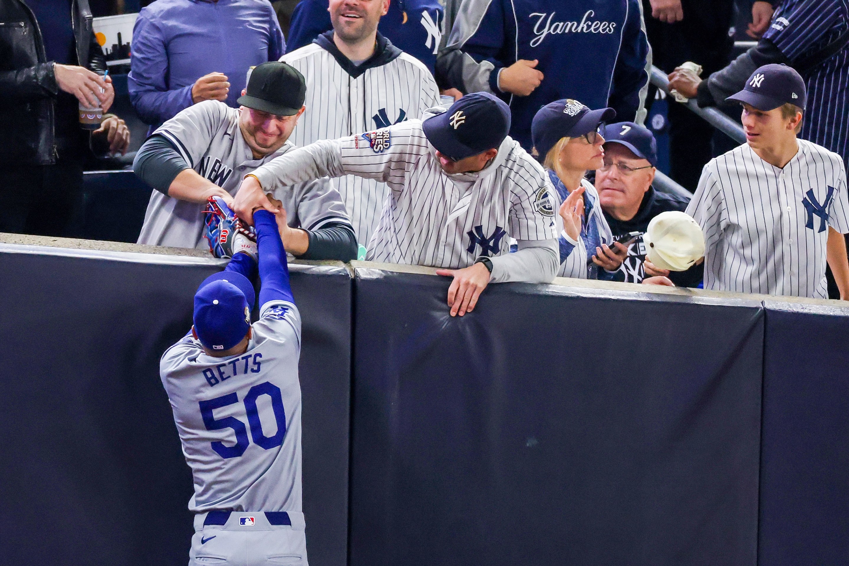 NEW YORK, NEW YORK - OCTOBER 29: Fans interfere with Mookie Betts #50 of the Los Angeles Dodgers as he attempts to catch a fly ball in foul territory during the first inning of Game Four of the 2024 World Series against the New York Yankees at Yankee Stadium on October 29, 2024 in the Bronx borough of New York City. The play resulted in an out. (Photo by Al Bello/Getty Images)