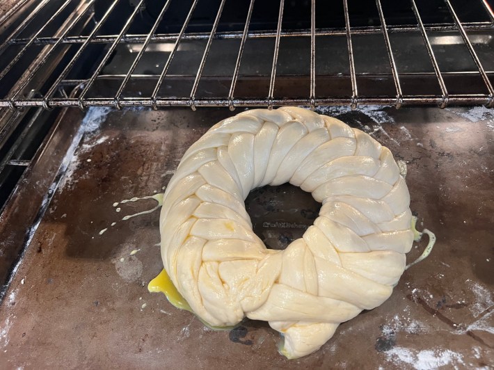 The weave rounded into a circle, brushed with egg, and headed into the oven.