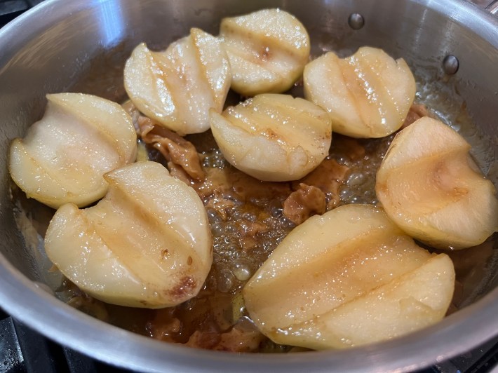 Halved and cored pears sauté in ruined, terrible caramel.