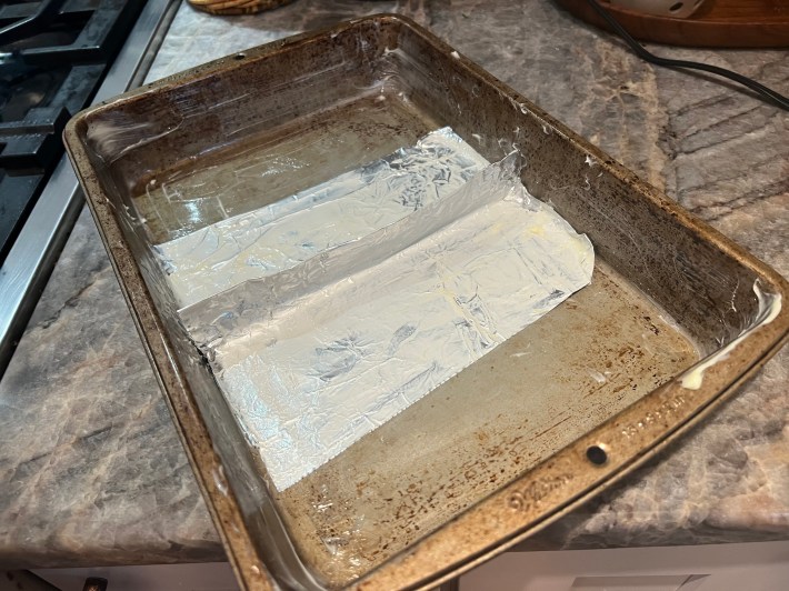 Foil shaped into a divider, smeared with butter and placed in the middle of a rectangular baking dish.