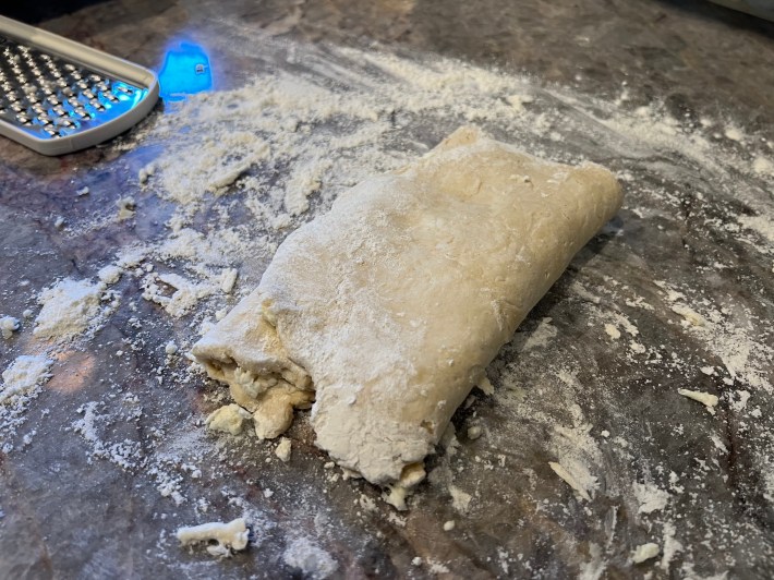 Dough folded like an envelope around some grated butter.