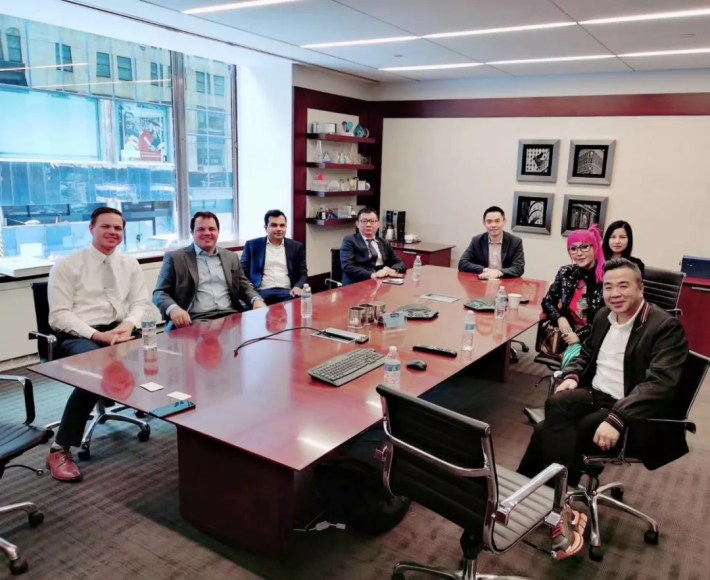 Xin Wu, Xiaoyan Huang, Jarom Heaps, and Michael Pope are among those seated at a conference table in this Yuren Manufacturing photo.