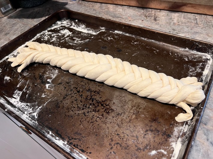 Seven ropes of bread dough braided together in a weave.