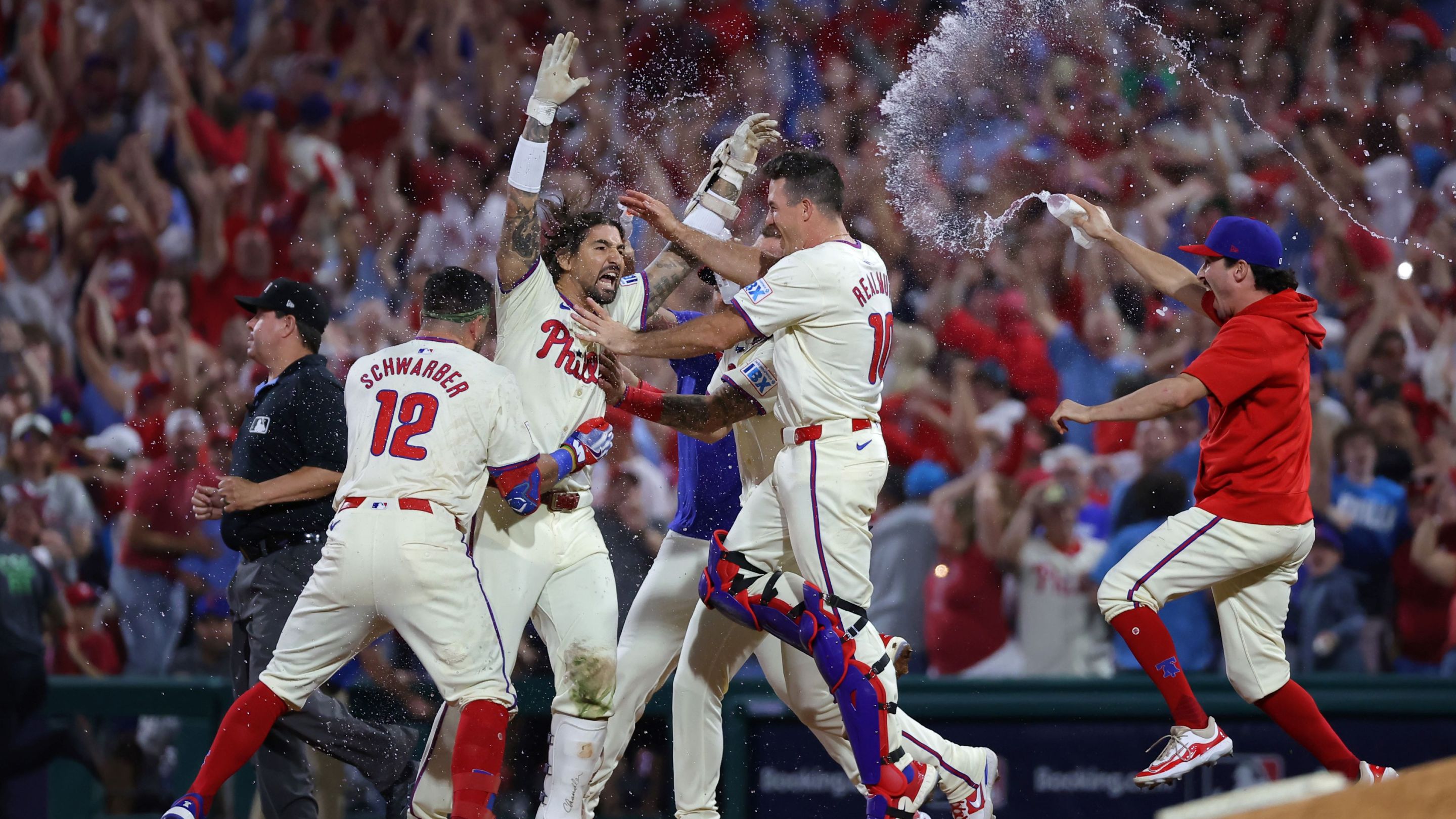 Nick Castellanos #8 of the Philadelphia Phillies celebrates with teammates after the game-winning hit to defeat the New York Mets.