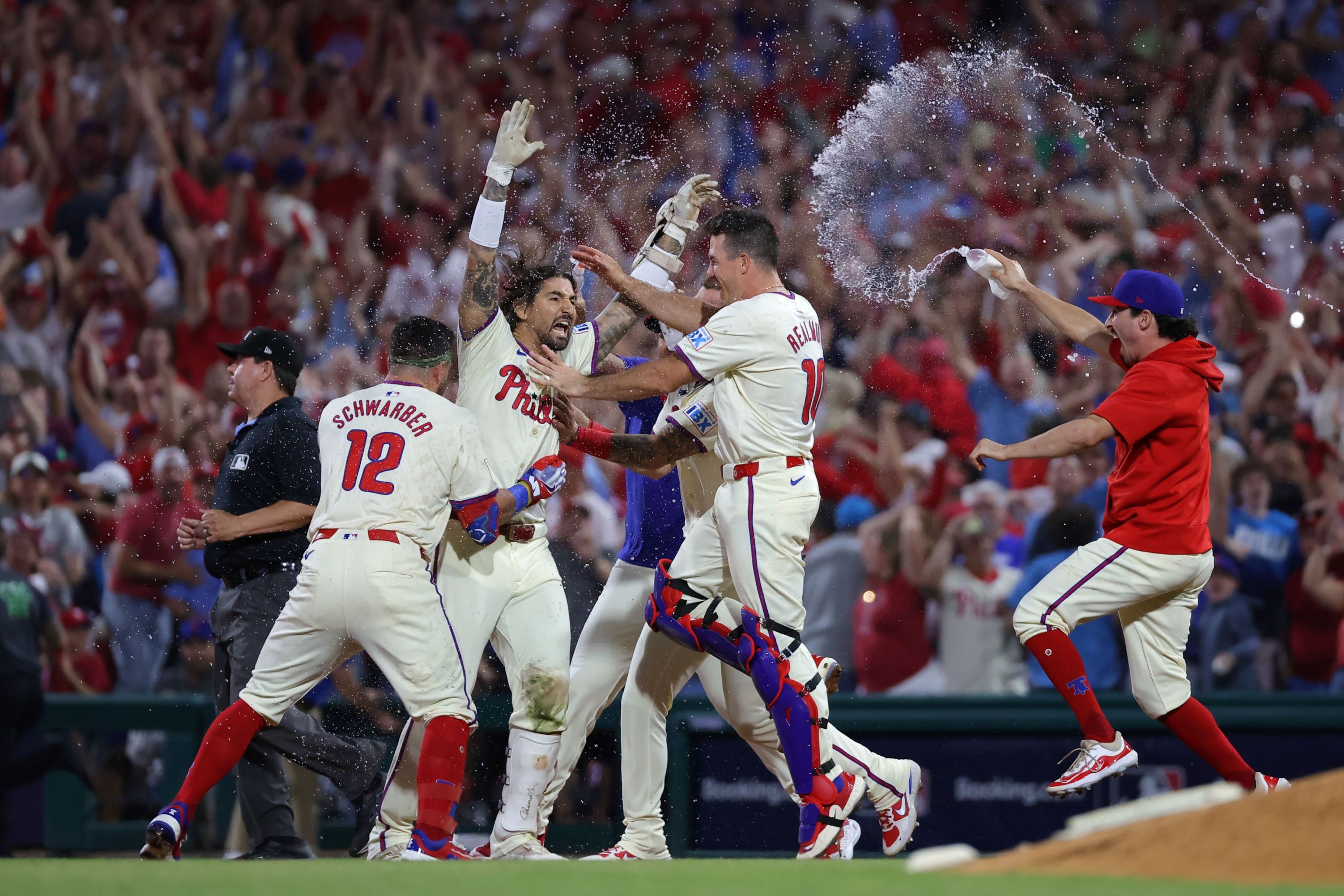 Nick Castellanos #8 of the Philadelphia Phillies celebrates with teammates after the game-winning hit to defeat the New York Mets.