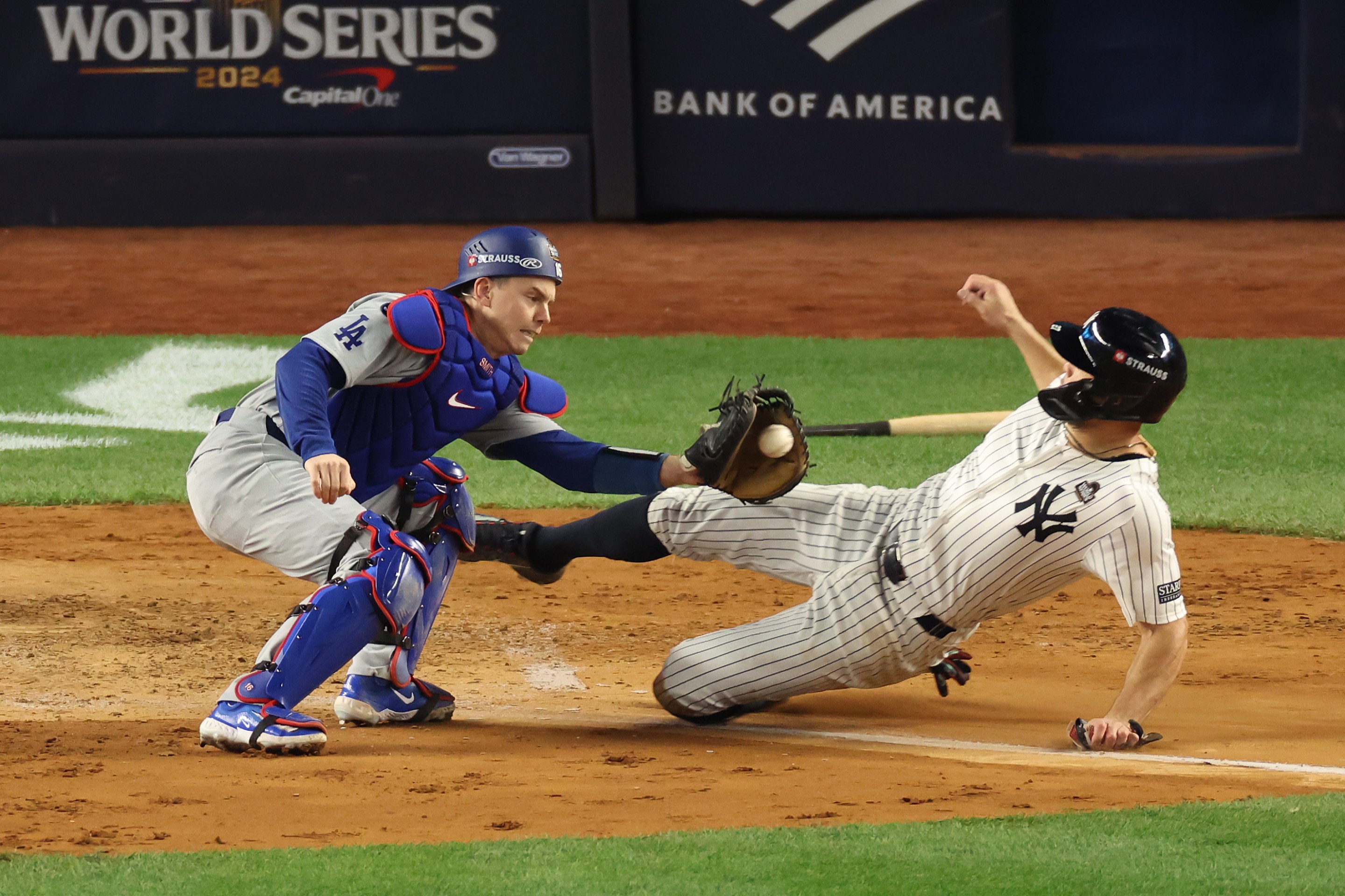 Will Smith #16 of the Los Angeles Dodgers tags out Giancarlo Stanton #27 of the New York Yankees at home plate.