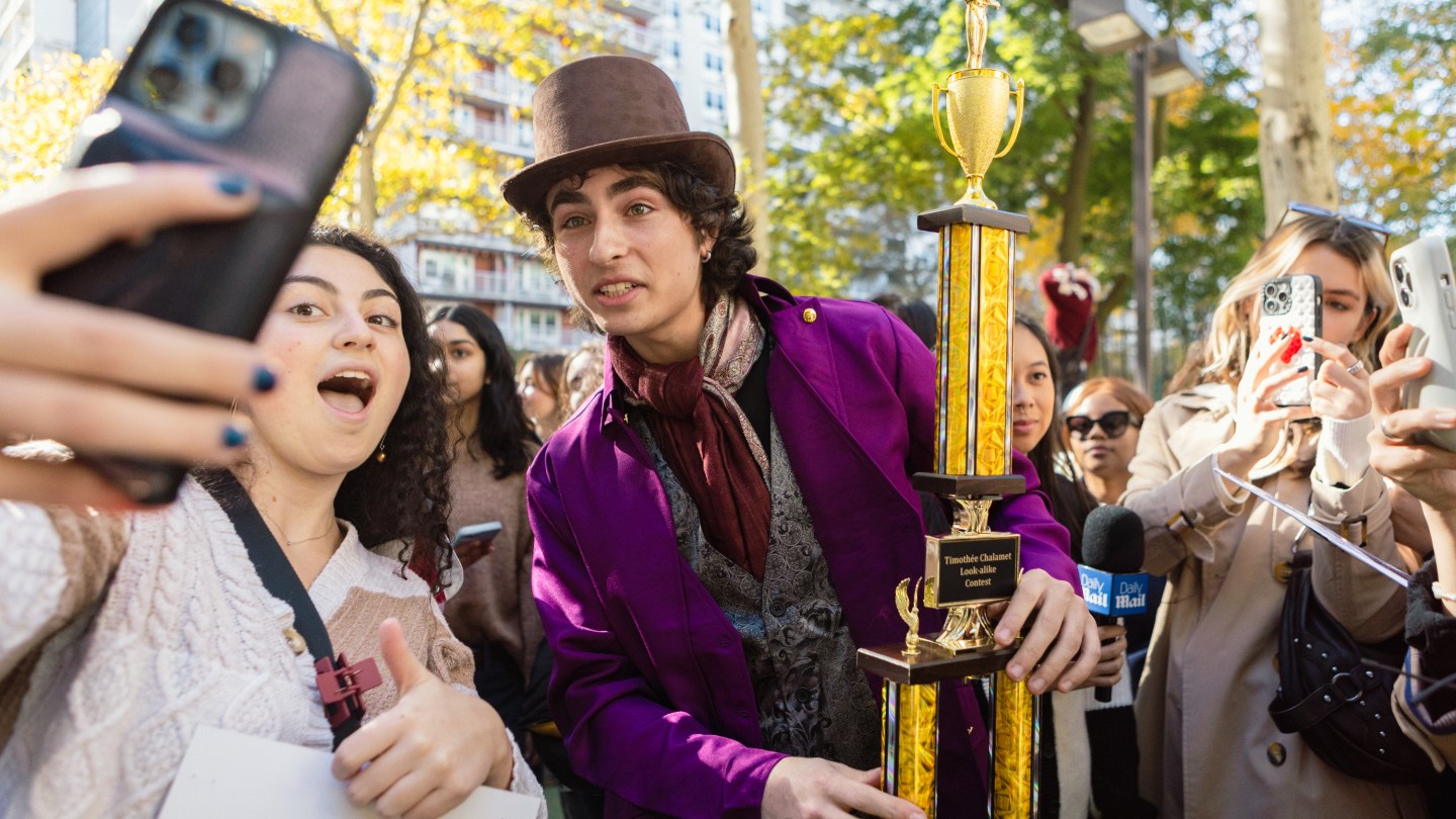 Timothee lookalike poses for a selfie with his trophy and a fan