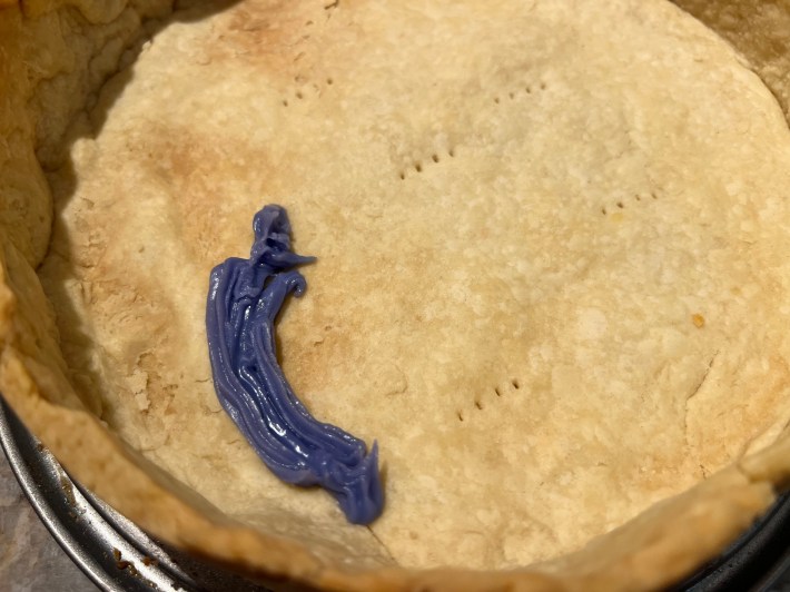 Purple decorative icing is used as calk inside the pie crust.