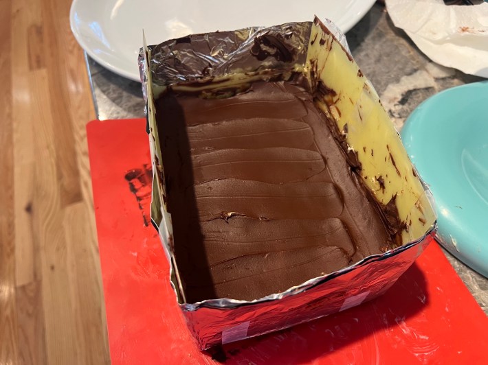 Ganache spread onto jaconde, inside a makeshift cake frame.