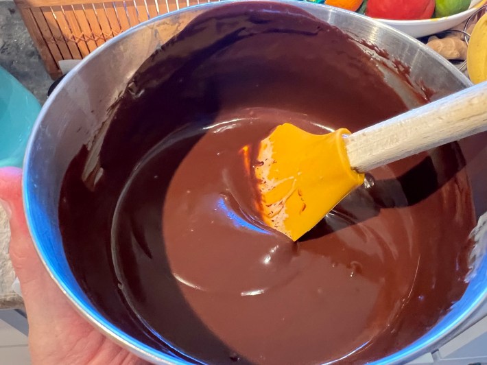 Melted chocolate ganache in a mixing bowl.