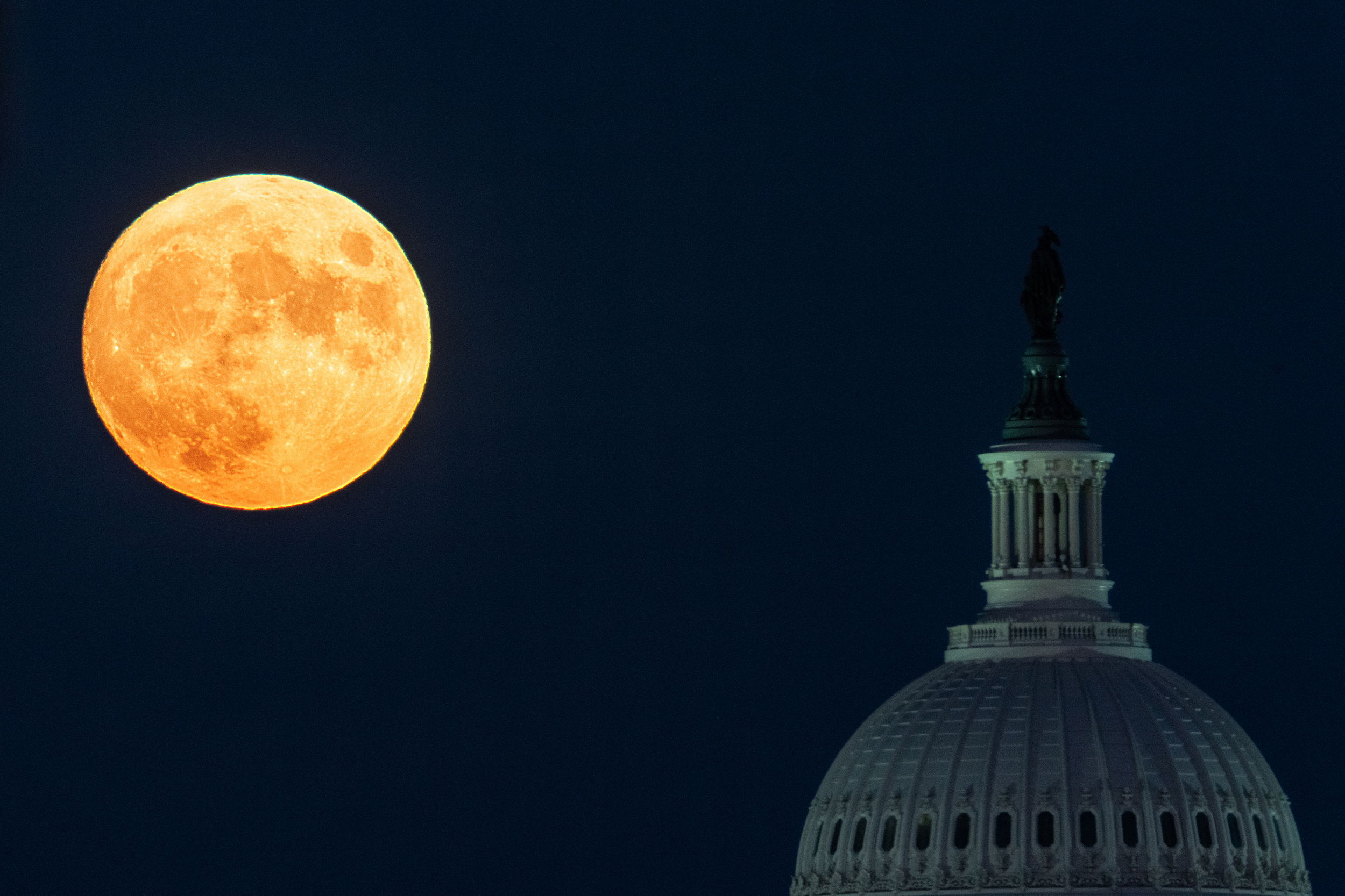 The Harvest Moon rises over the U.S. Capitol dome in 2022.