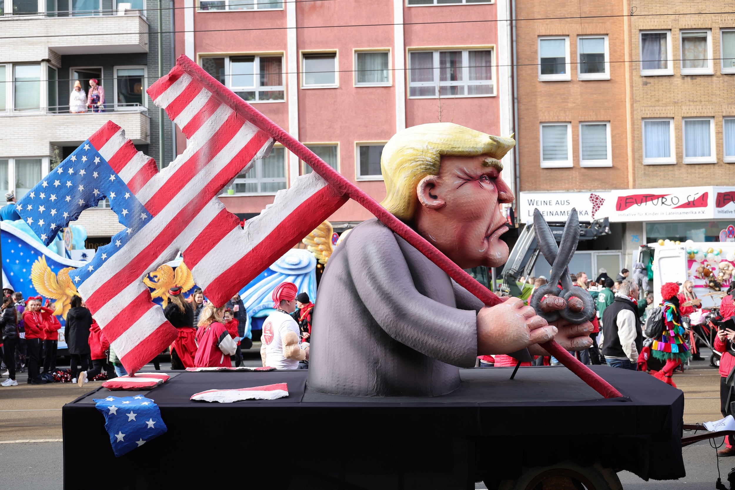 DUSSELDORF, GERMANY - FEBRUARY 12: A parade float shows an effigy of Donald Trump holding a pair of scissors in his hand with a cut-up US flag in the shape of a swastika at the annual Rose Monday Carnival parade on February 12, 2024 in Dusseldorf, Germany. The Mainz and Dusseldorf Rose Monday parades are known for their biting political satire. Cities in western Germany are celebrating the traditional Rhineland Carnival this week, culminating in today's Rose Monday parades. (Photo by Andreas Rentz/Getty Images)