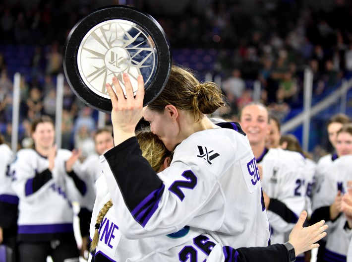 LOWELL, MASSACHUSETTS - MAY 29: Lee Stecklein #2 of Minnesota kisses Kendall Coyne Schofield #26 of Minnesota after receiving the Walter Cup from her after the win over Boston during Game Five of the PWHL Finals at Tsongas Center on May 29, 2024 in Lowell, Massachusetts.