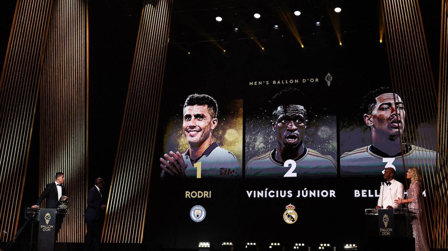 Manchester City's Spanish midfielder Rodri (L) receives the Ballon d'Or award from former President of Liberia and former Liberian football player George Weah (2L) as he wins in front of second-placed Real Madrid's Brazilian forward Vinicius Junior and third-placed Real Madrid's English midfielder Jude Bellingham during the 2024 Ballon d'Or France Football award ceremony at the Theatre du Chatelet in Paris on October 28, 2024.